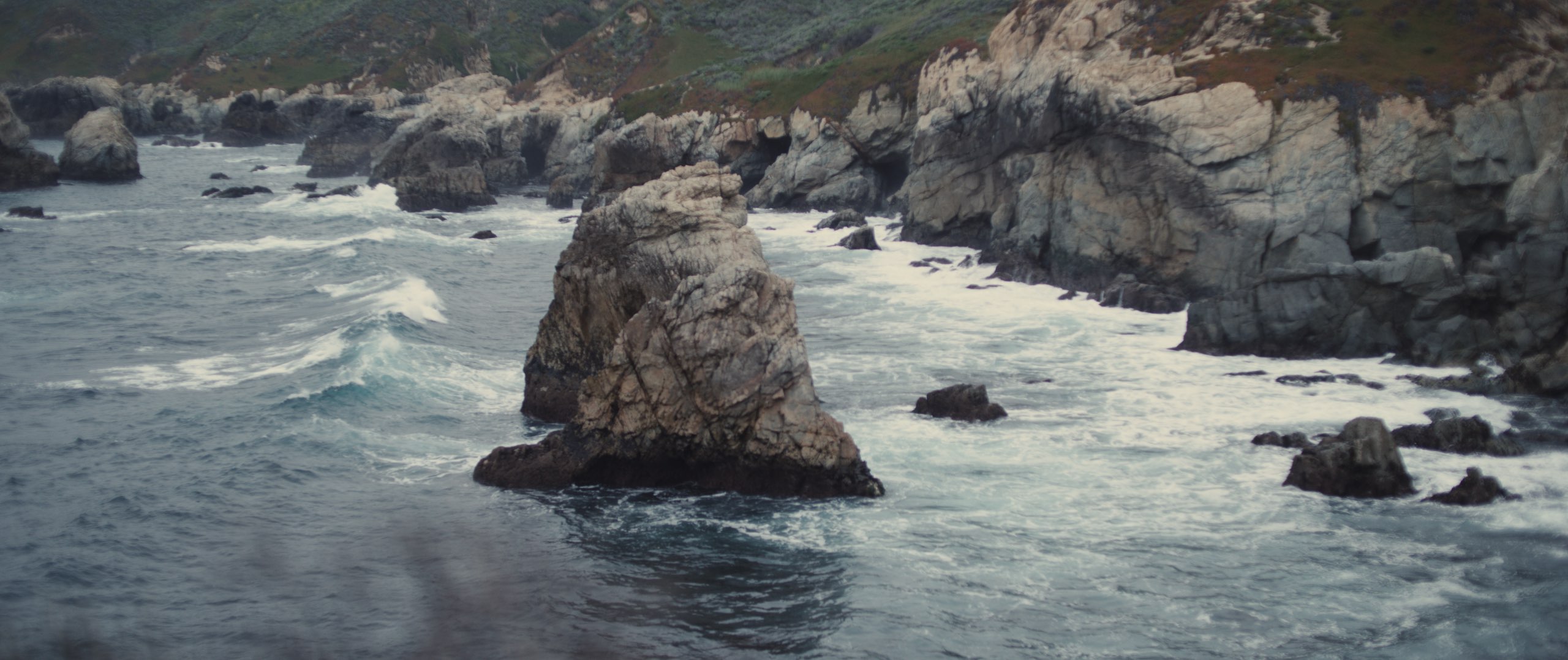 The Dailies Season 2 Episode 3 Komuso Big Sur with view of a large rocky outcrop in the water with cliffs nearby