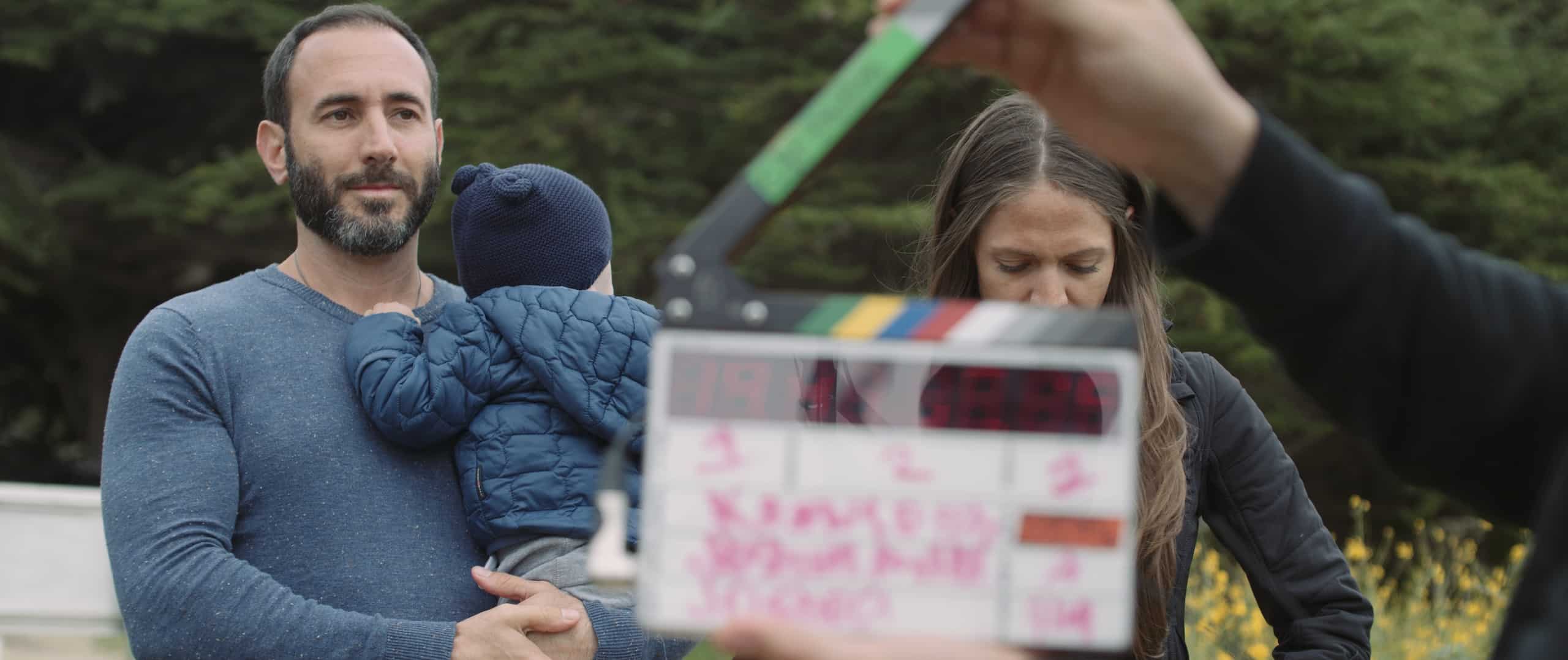 Top 10 Essential Video Filming Techniques with man holding child and woman preparing for a shoot with a crew member using a clapboard in front of them
