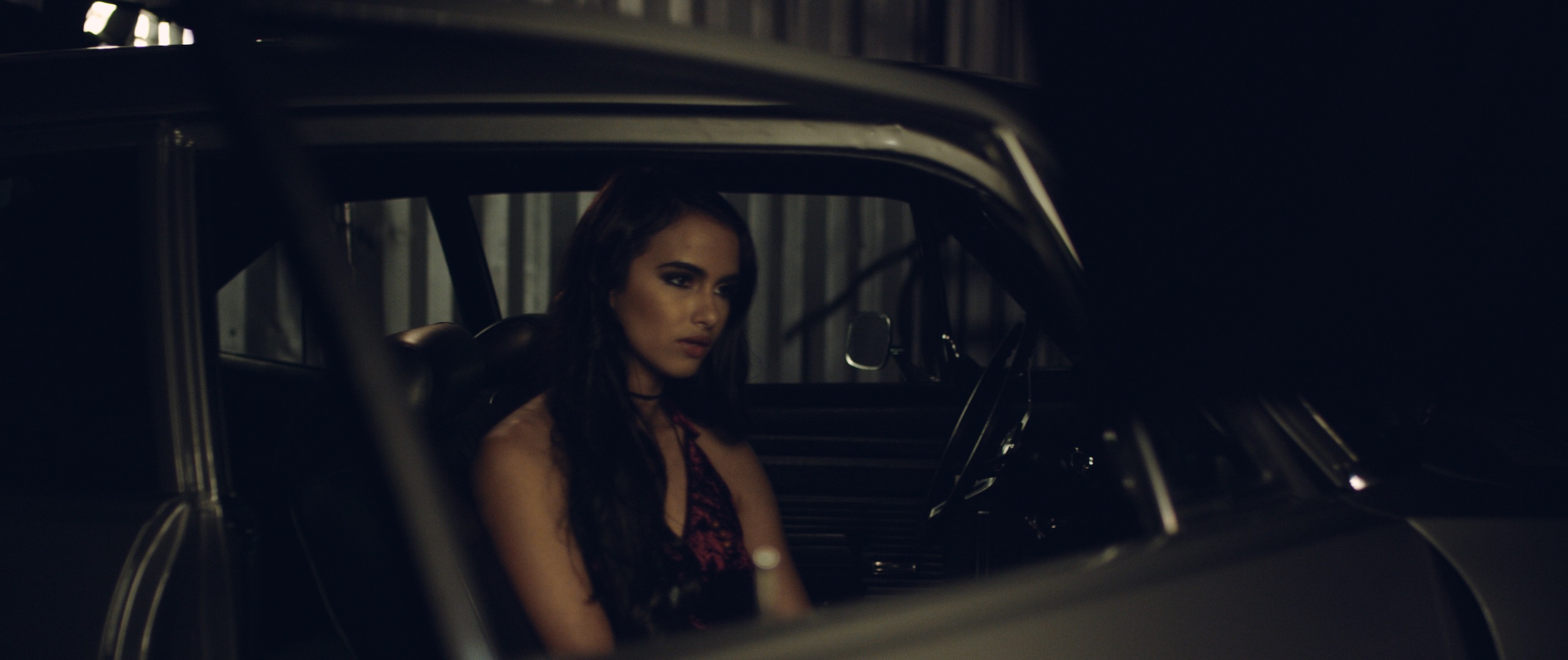 The Dailies Episode 202 BTS Footage with closeup headshot of Mercedes Gutierrez sitting in the driver's seat of a car