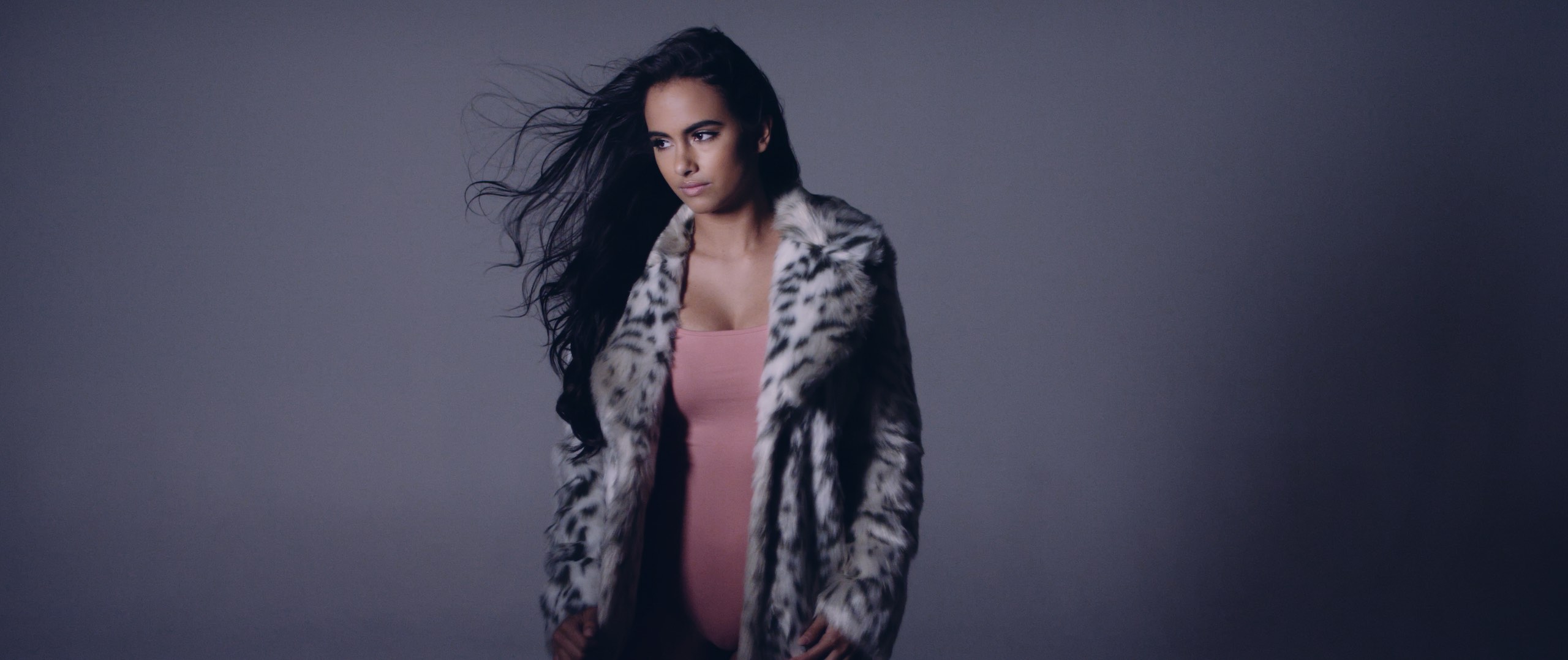 The Dailies Episode 202 BTS Footage showing model with long black hair wearing a black and white fur coat
