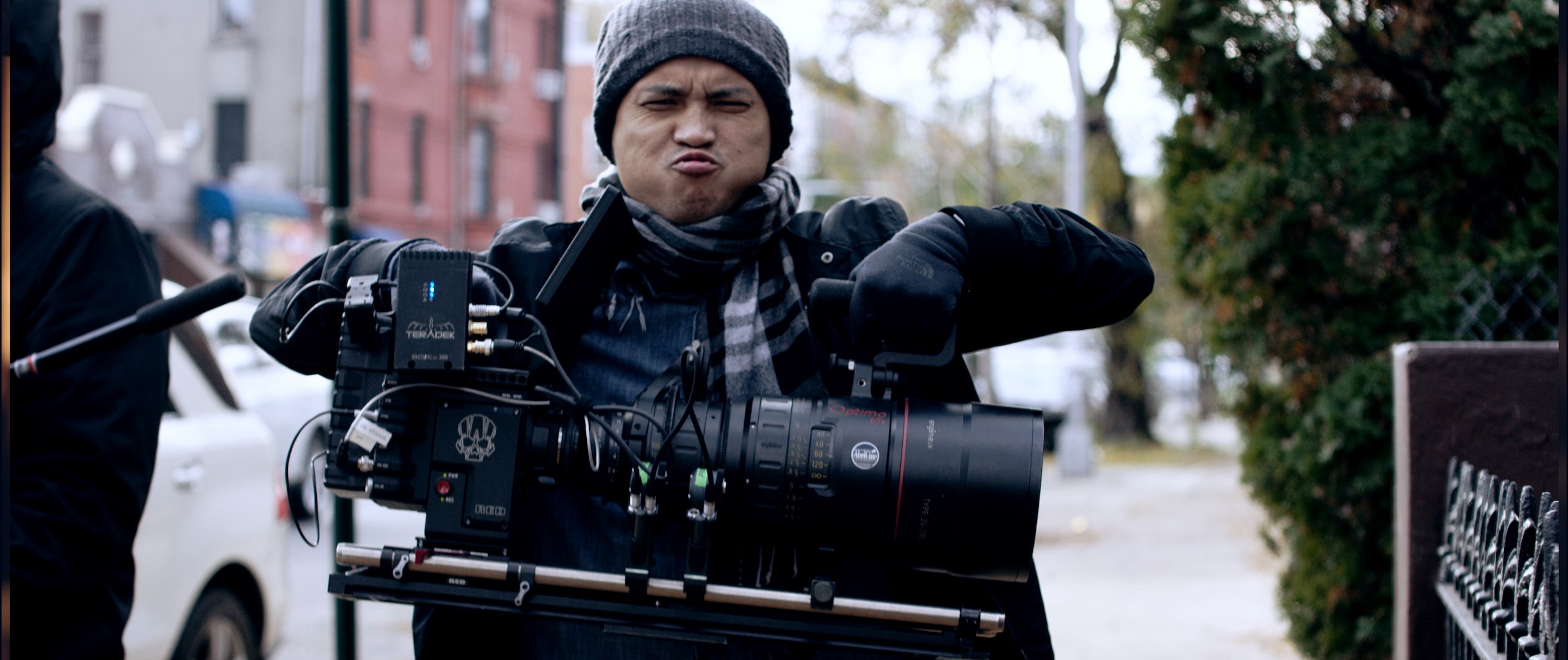 The Dailies Season 2 Episode 8 RED Cameras RED cameras Crew member wearing gray knit cap grimacing as he lifts camera