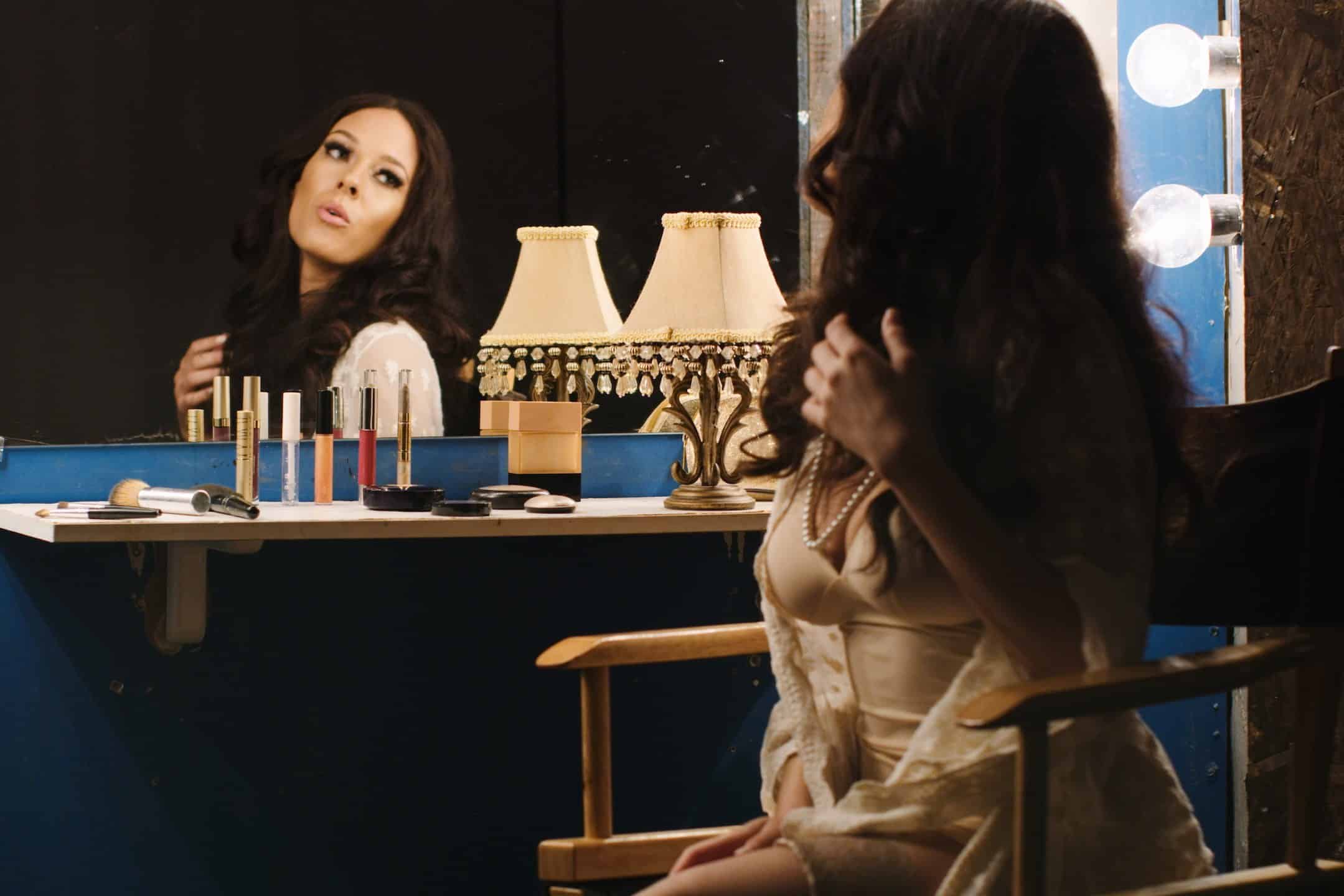 Vanity Closet with female model sitting at a makeup table looking in the mirror