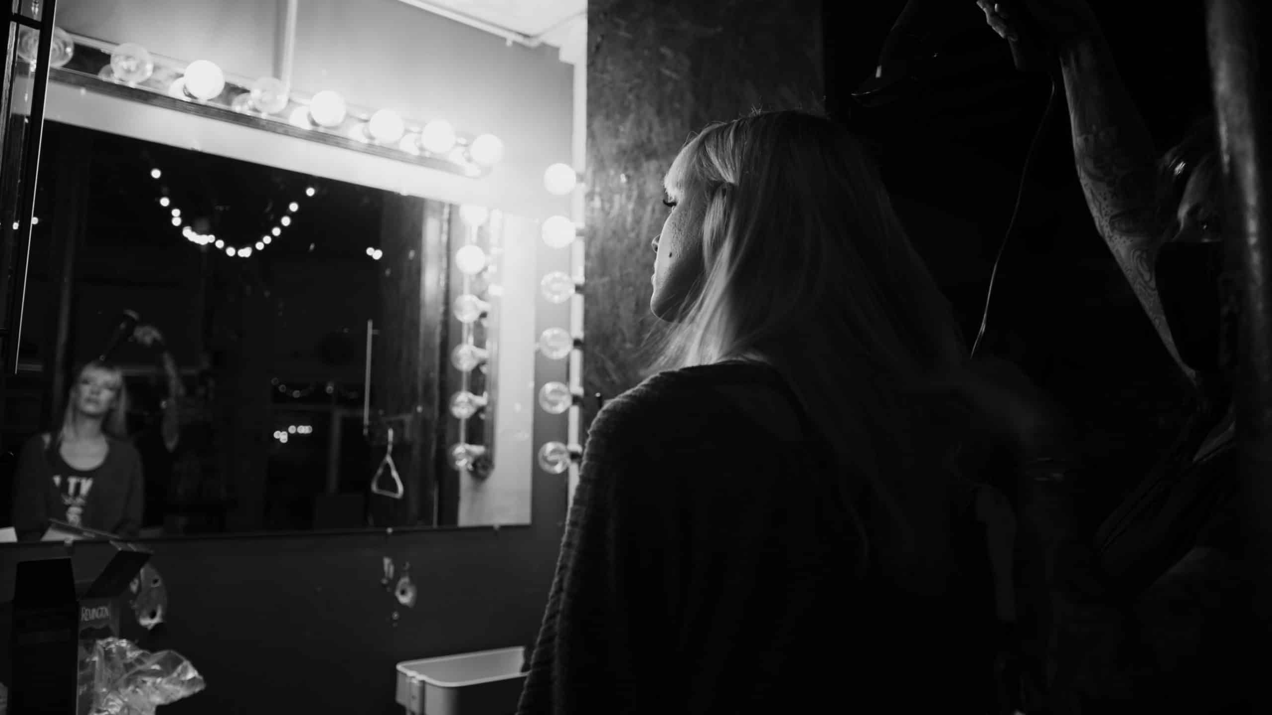 Uncreative Shop AJ Knapp with black and white view from behind of makeup artist working on model in makeup area