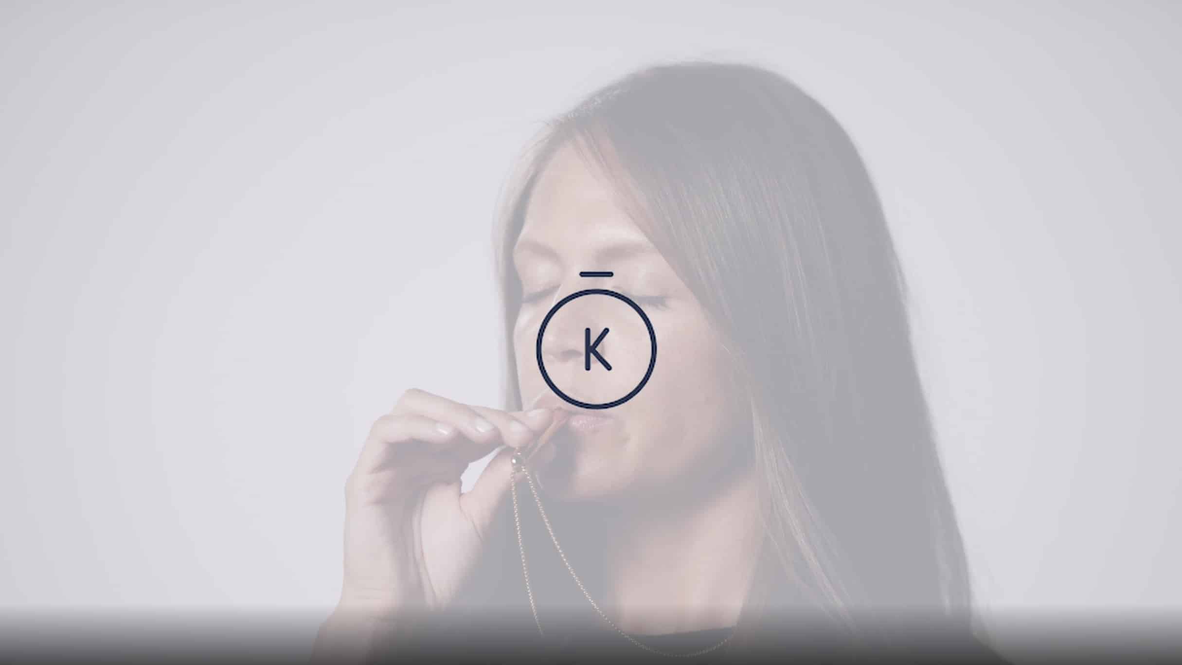 Komuso Testimonial Video with black Komuso logo on dimmed backdrop of woman blowing the Komuso whistle