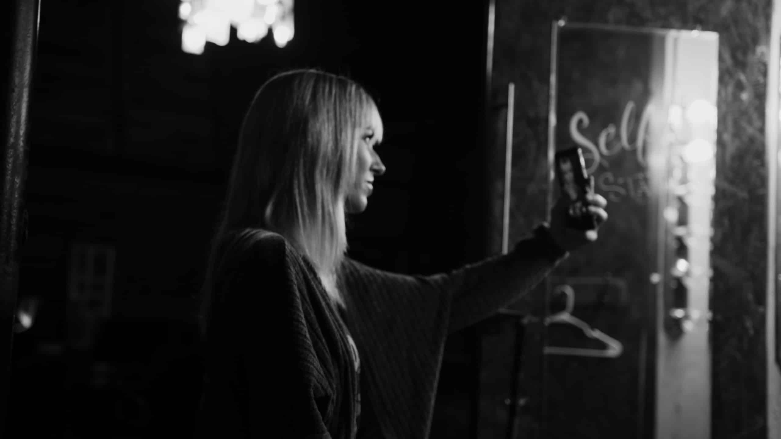 Uncreative Shop AJ Knapp with black and white side view of model taking a selfie on phone
