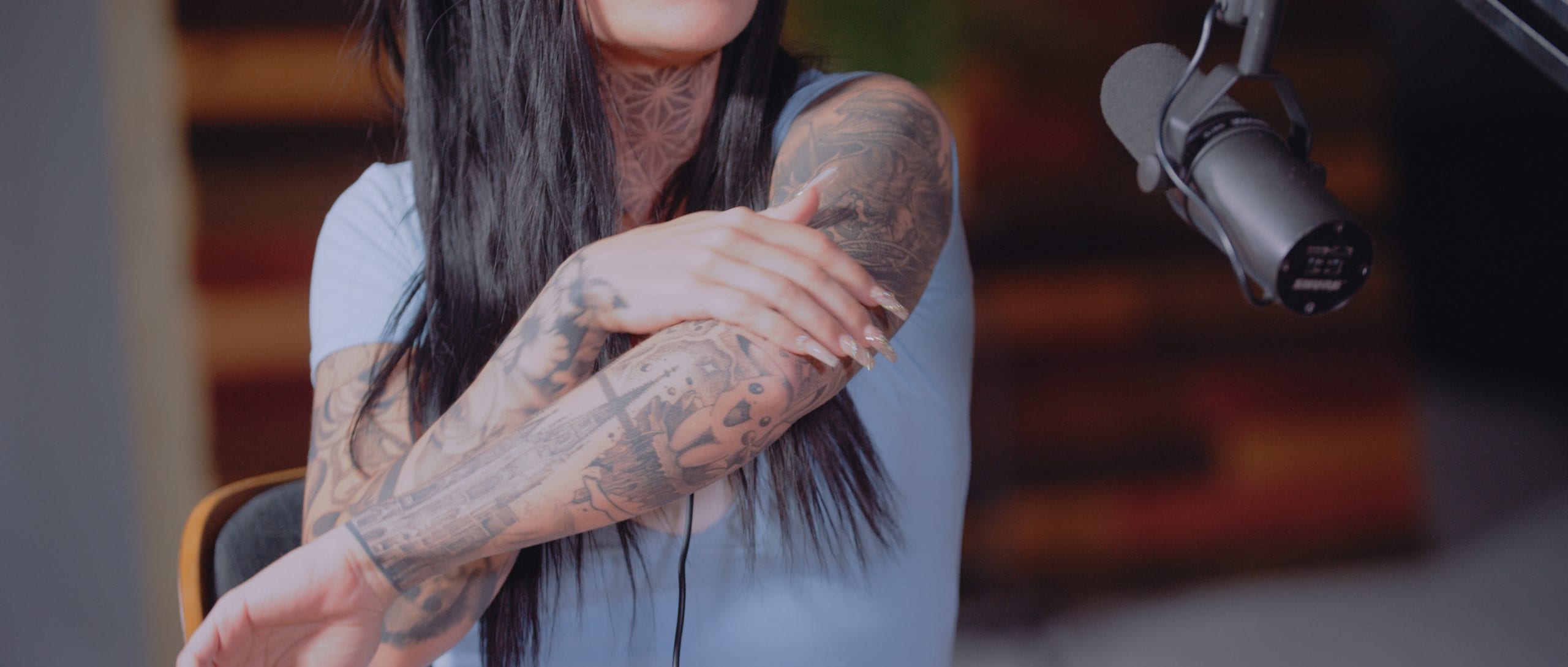 Uncreative Radio with Jaquelyn Puma with closeup of her tattooed arms by a microphone