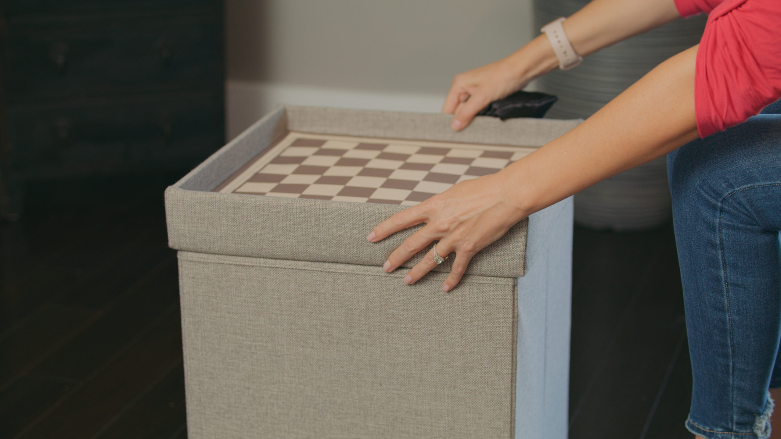 Audy Global Enterprise Ottoman Woman setting up checkers board on a box