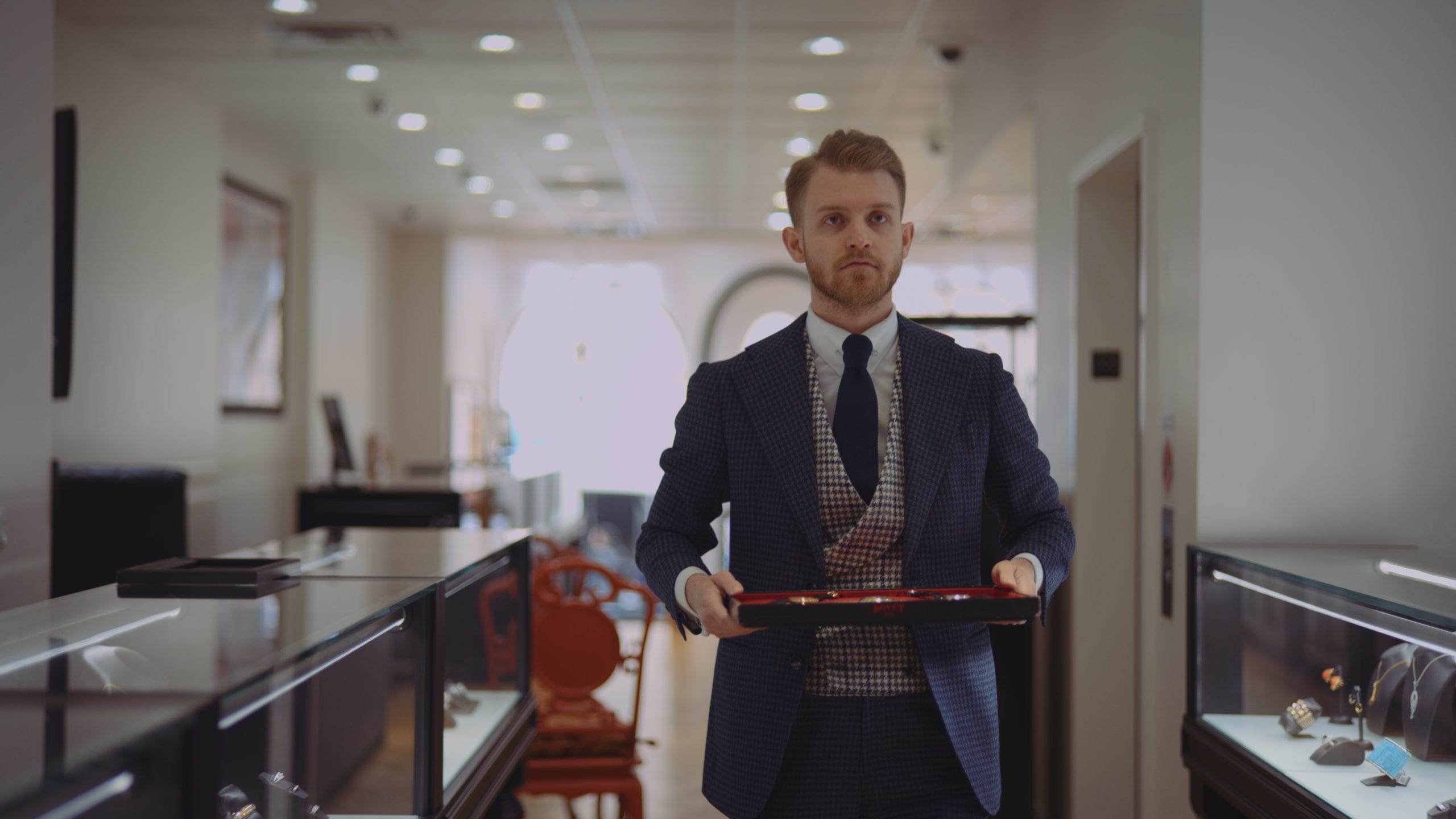 Geneva Seal Chicago Man in a suit and tie carrying tray of jewels in a jewelry shop