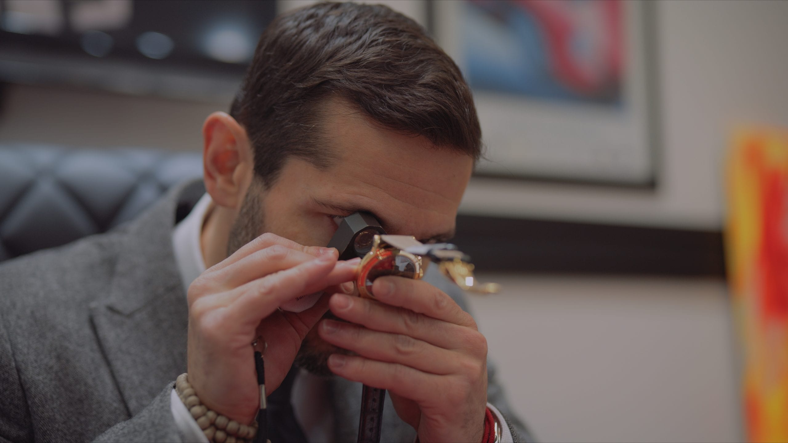 Geneva Seal Chicago Jeweler looking at the back of a watch with a pocket magnifier
