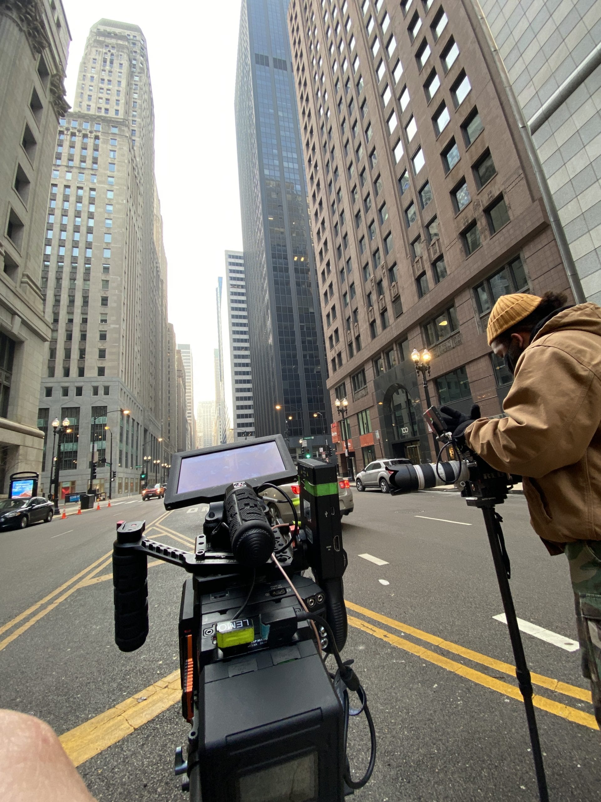 RED Camera being used on a street in a city with crew around it
