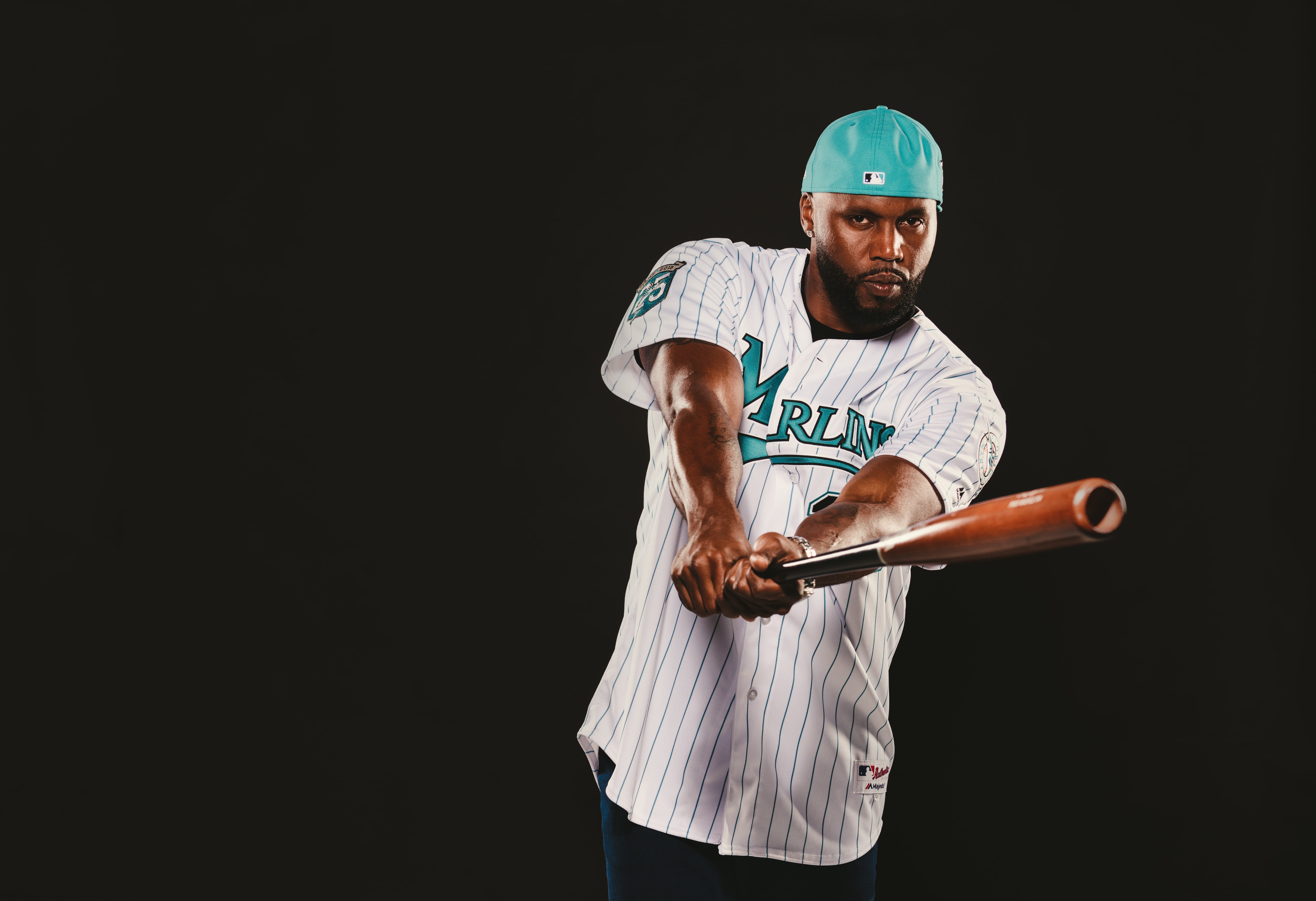 IU C&I Studios Ball Cap Liner Marlins baseball player wearing cap backwards posing for the camera holding a bat in a batting pose