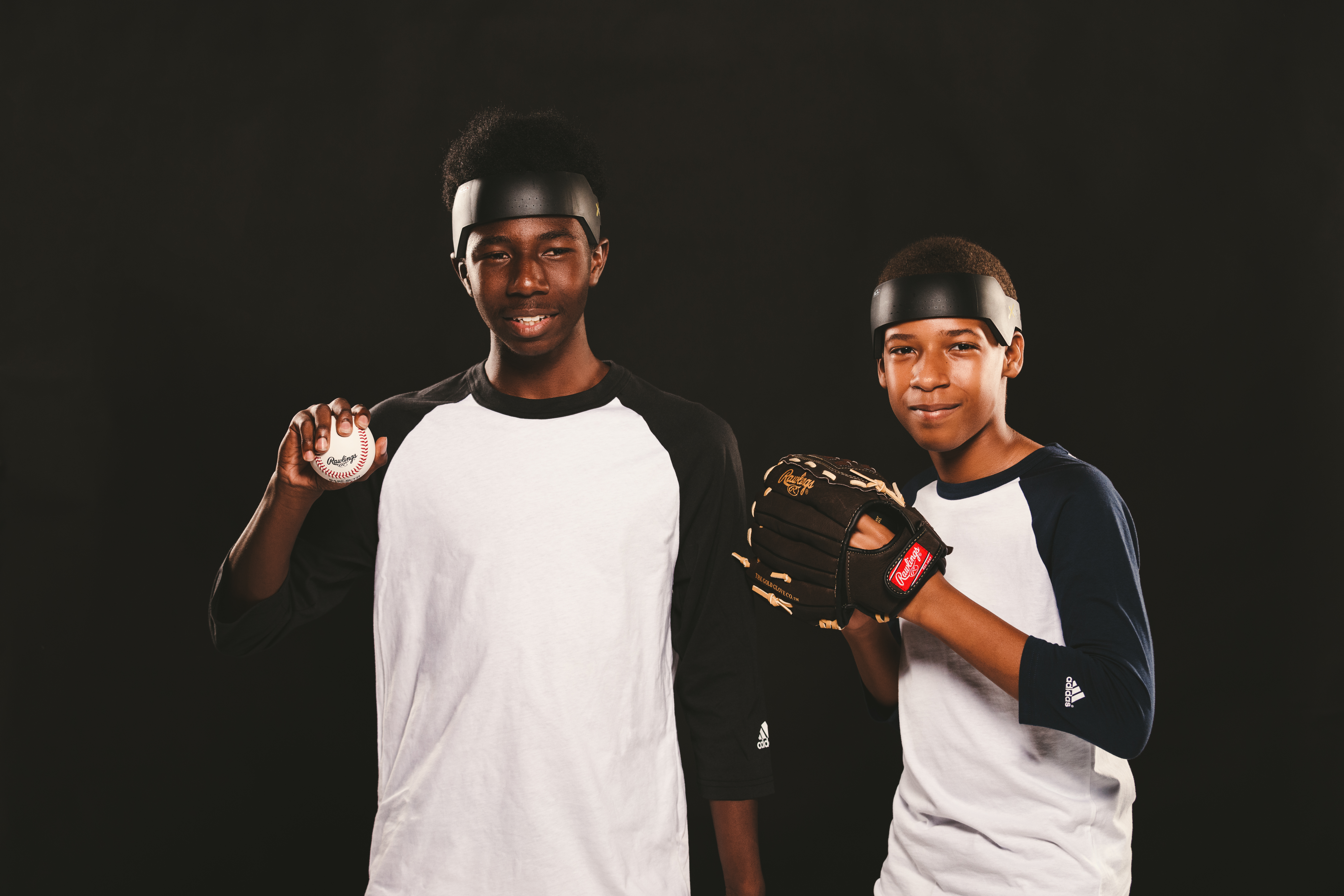 IU C&I Studios Ball Cap Liner Two young baseball players wearing BCLs with one holding a baseball and the other wearing a baseball mitt posing for the camera