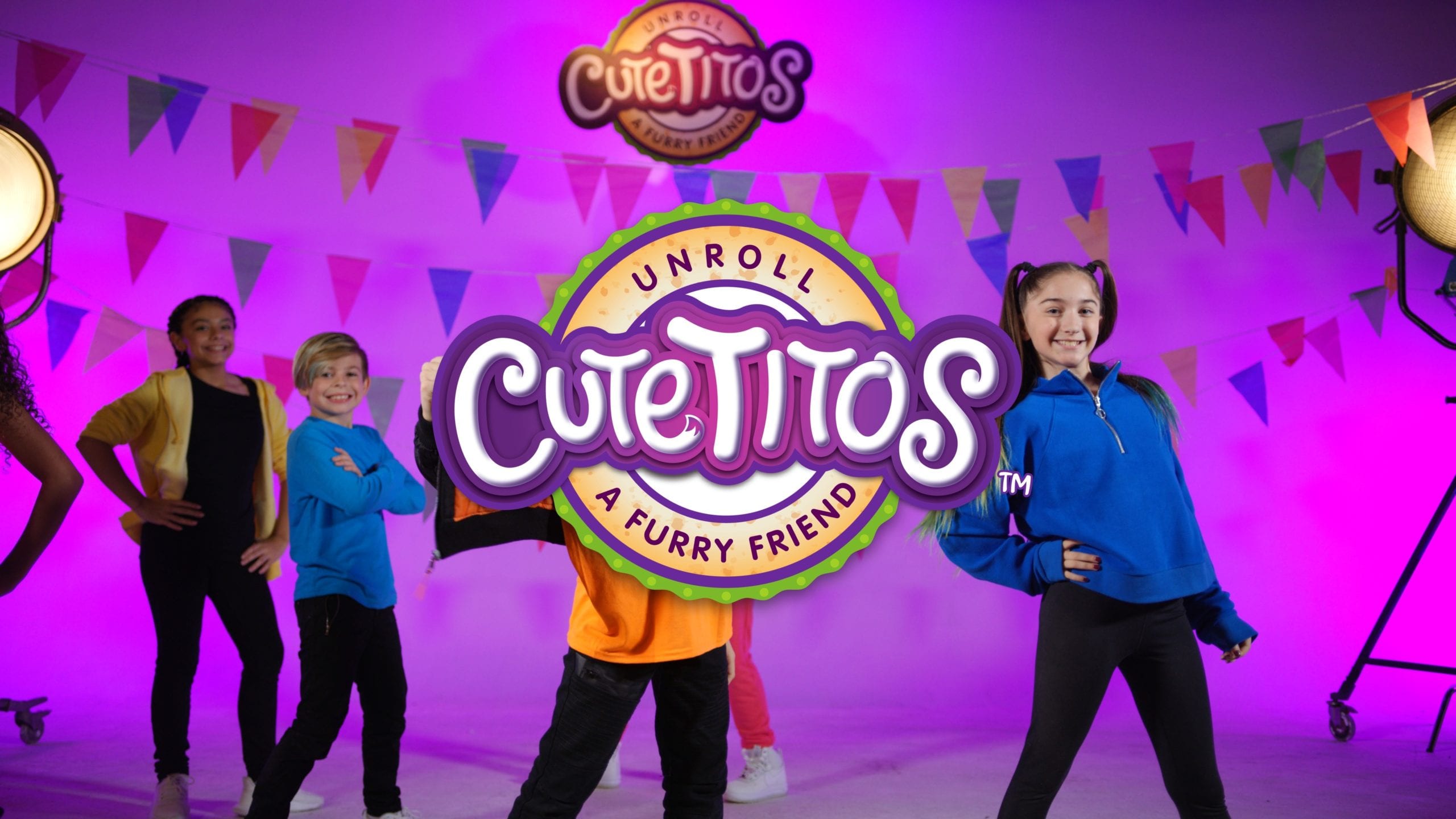 IU C&I Studios Page Basic Fun Cutetitos Logo superimposed on group of smiling boys and girls posing on set with purple background