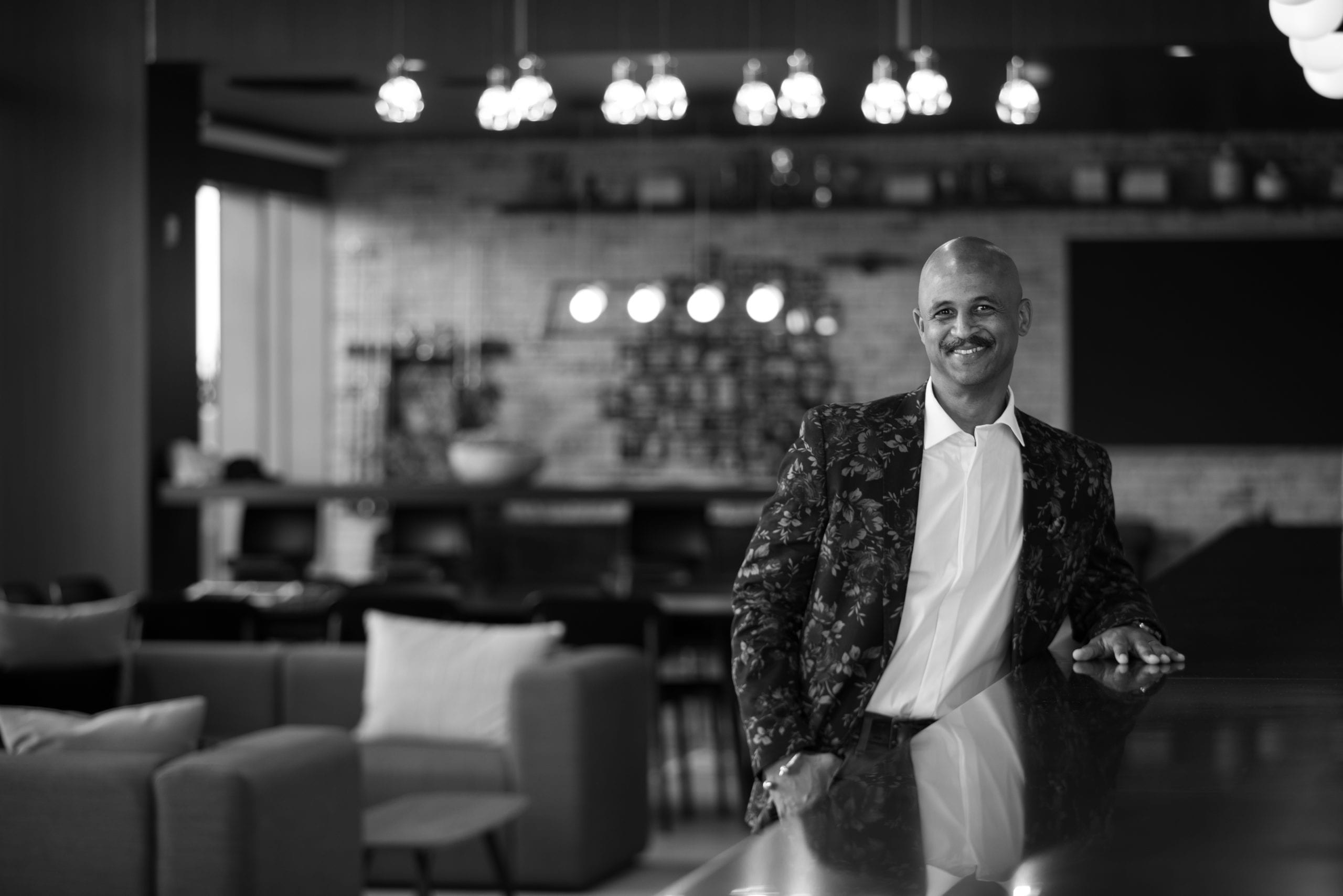 Bald African American male model with moustache posing by a bar