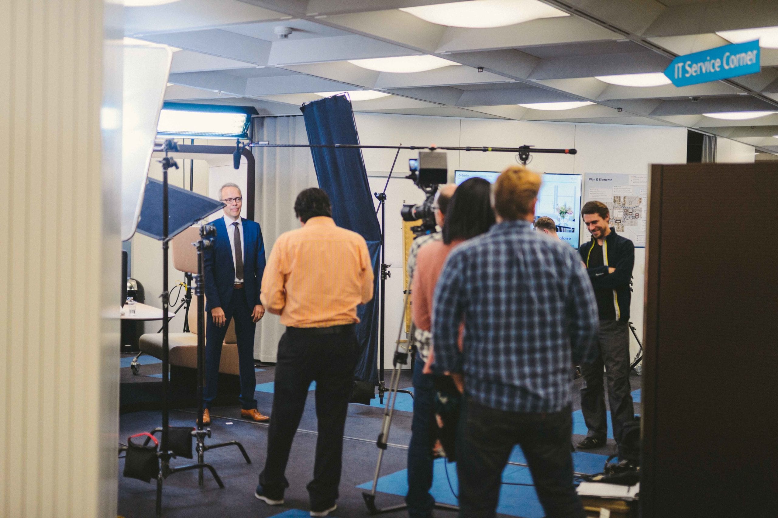 IU CI Studios Page Storytelling Basel Switzerland Citrix Innovation Awards Staff standing around with equipment while man in a suit waits to speak