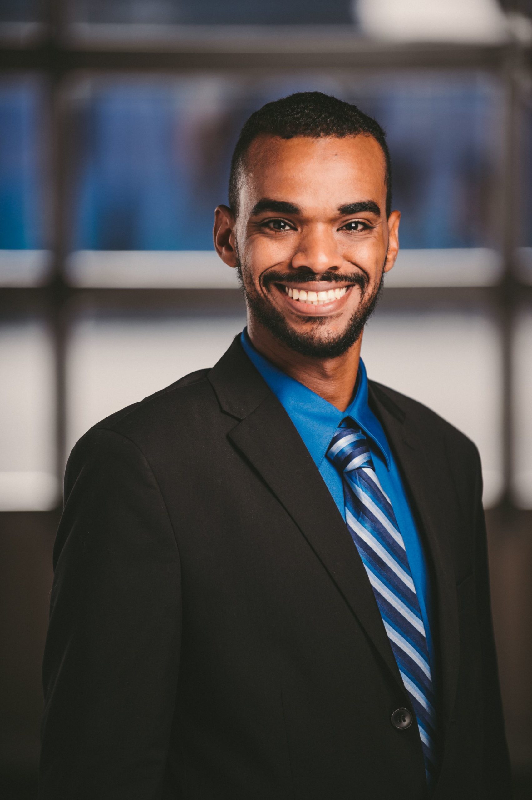 IU C&I Studios Portfolio Van Horn Law Group Head Shot of man smiling wearing a black suit with blue shirt and striped tie