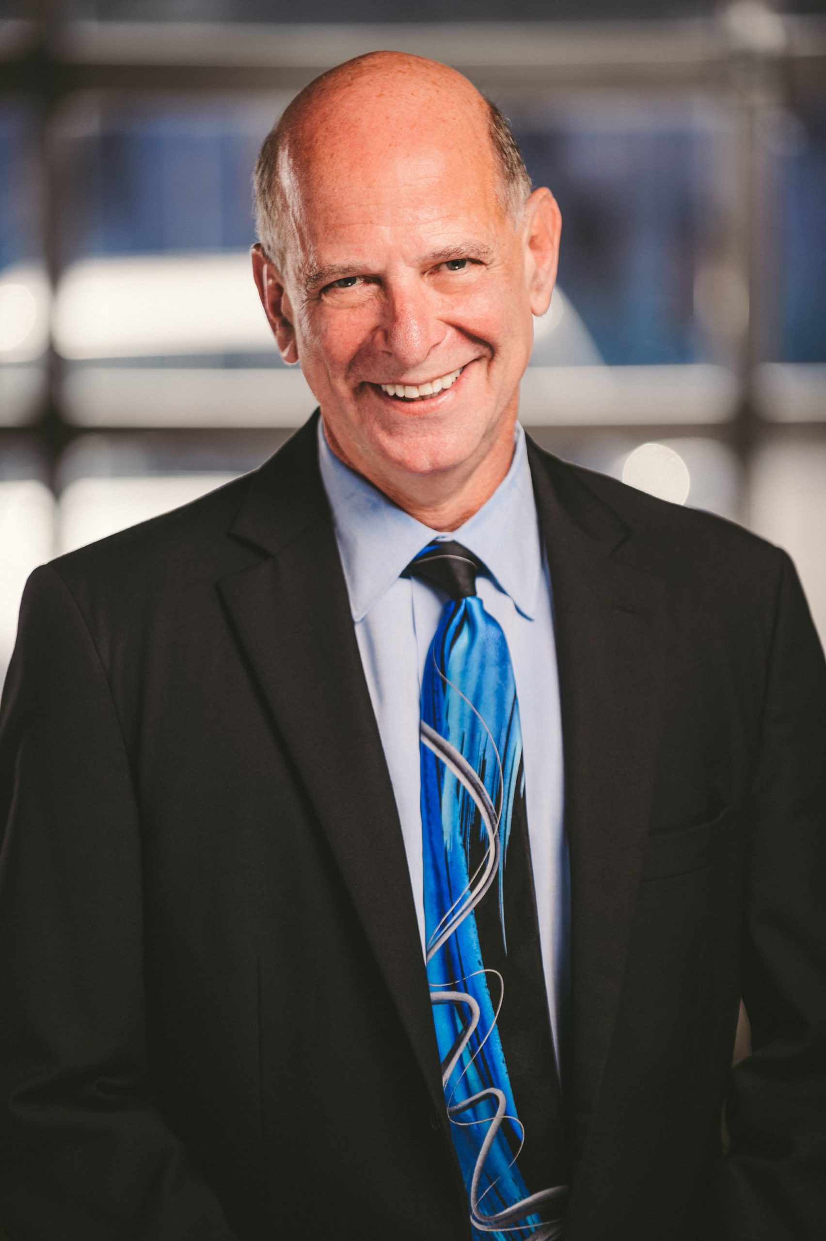 IU C&I Studios Portfolio Van Horn Law Group Head Shot of partially bald man wearing black suit with light blue suit and blue tie with patterns