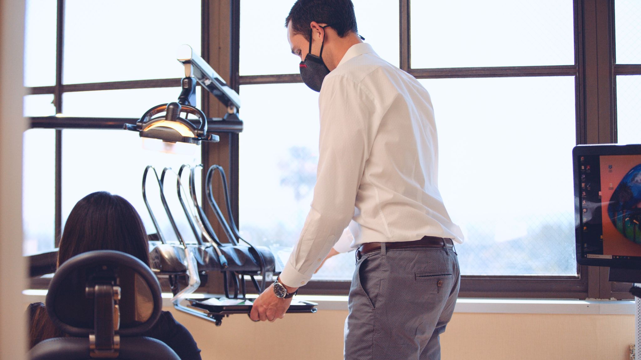 Side profile of male dentist arranging equipment