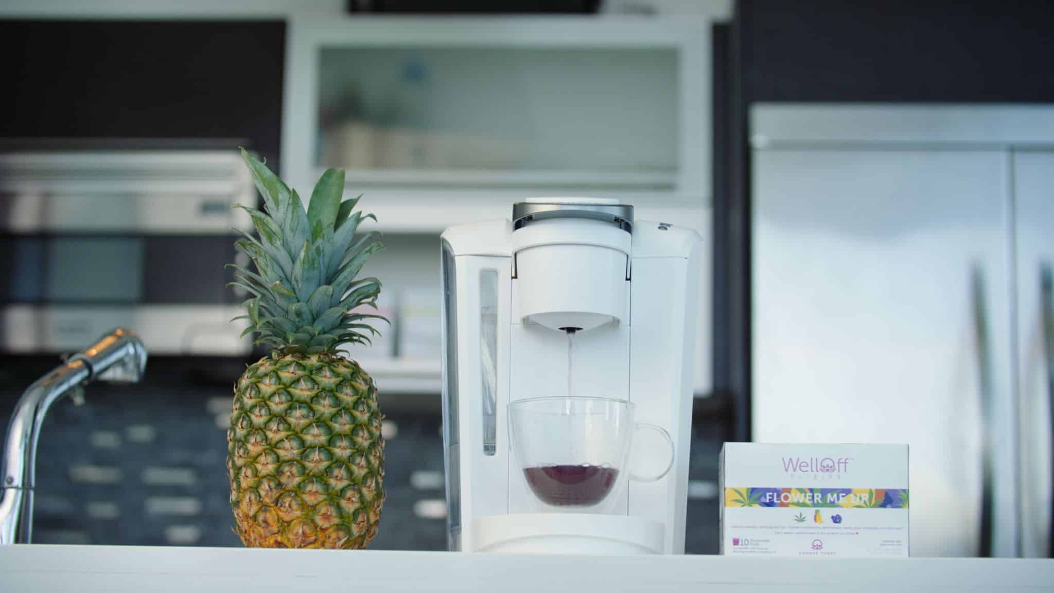 Kitchen Flower Me Up product on display with a pineapple and drink maker in a kitchen
