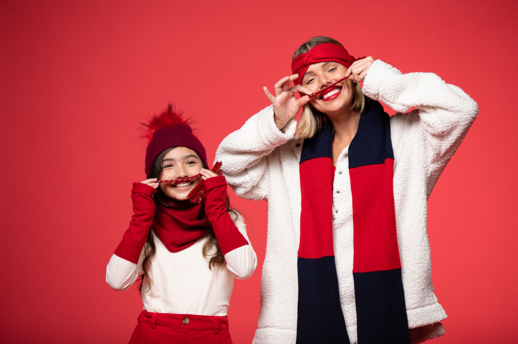 IU C&I Studios Portfolio BB Sheep Lifestyle Colors PROOF Girl model wearing red headband, scarf and pants along with white top and female model wearing red hand band, white jacket and black and red scarf against a red backdrop