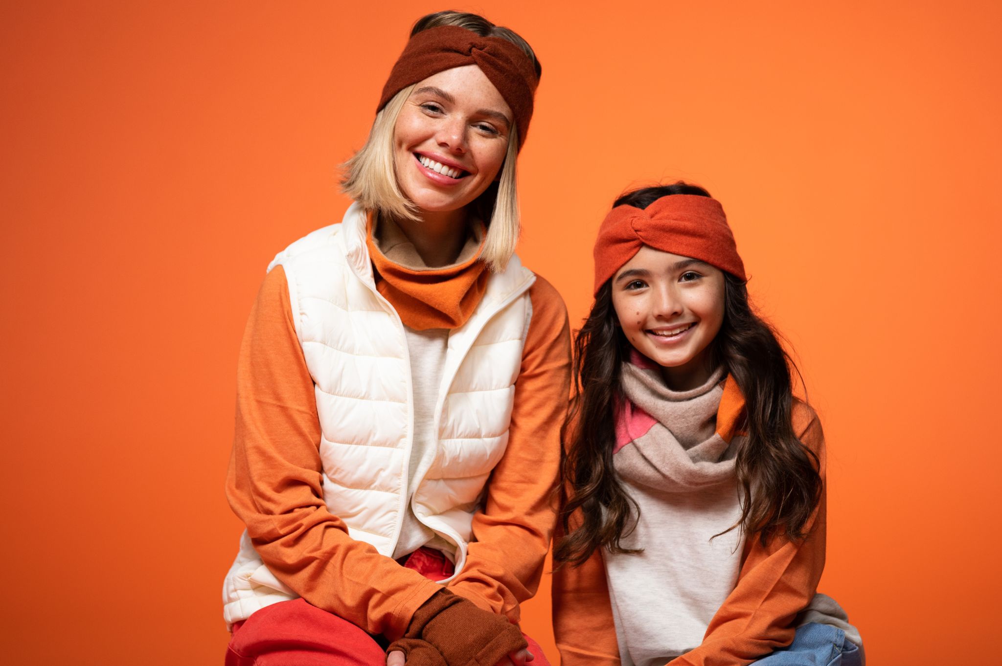 IU C&I Studios Portfolio BB Sheep Lifestyle Colors PROOF Female and girl models posing for the camera smiling against an orange backdrop