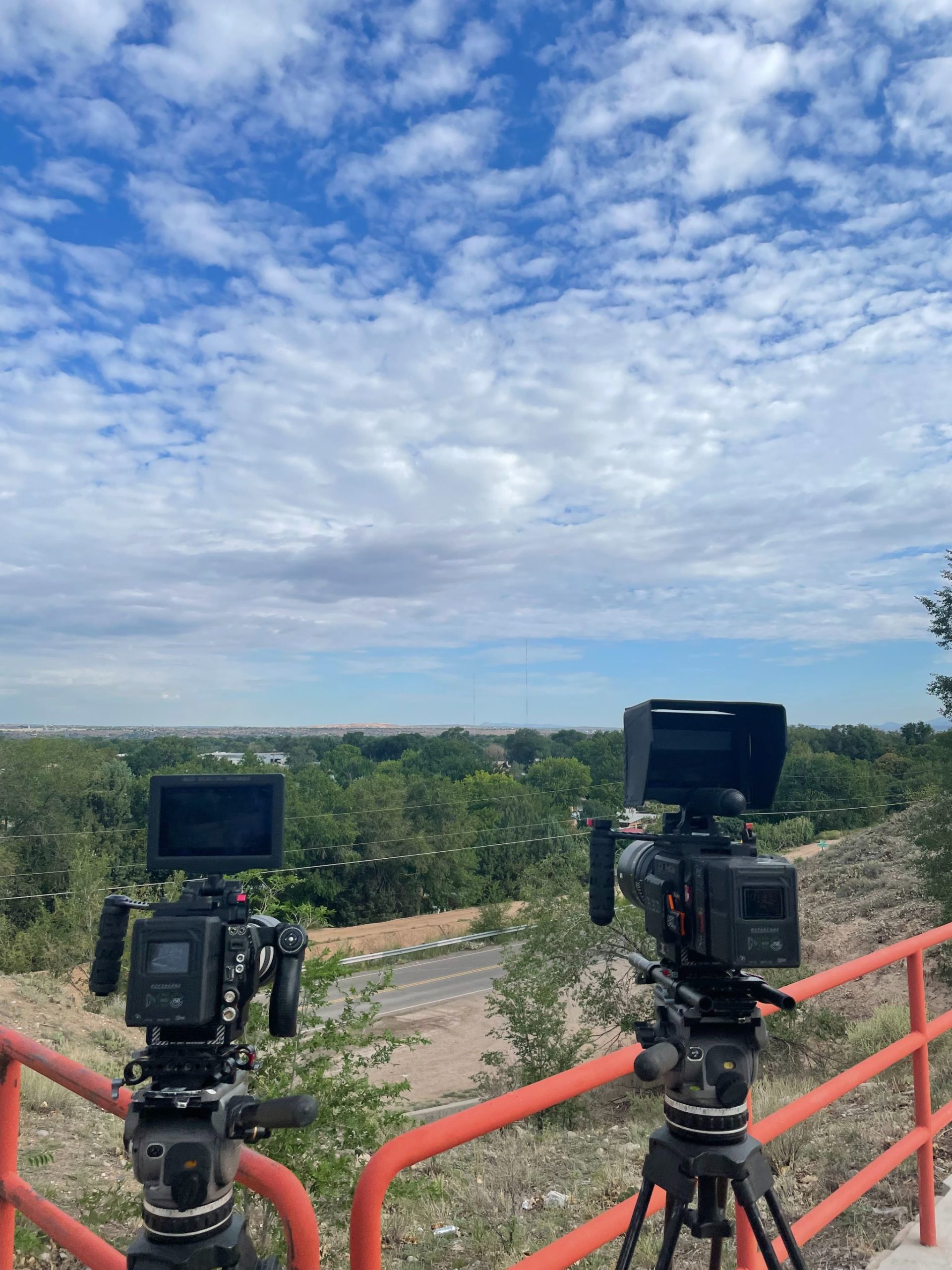 IU C&I Studios Portfolio Closeup of two video cameras set up by an orange railing overlooking a valley