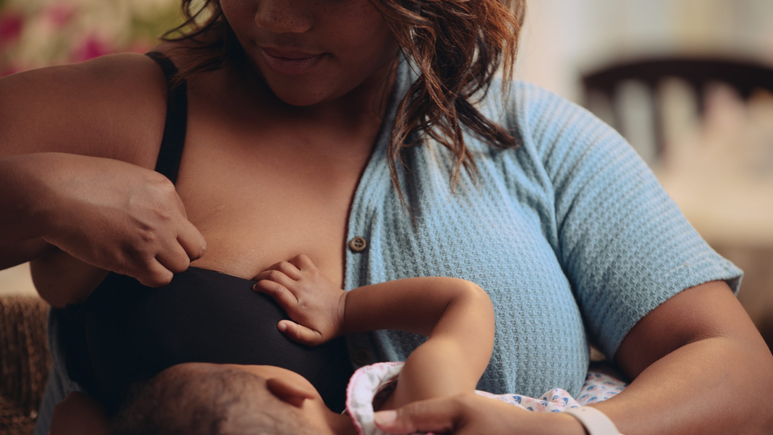 Closeup of woman breastfeeding a baby wearing the black bra