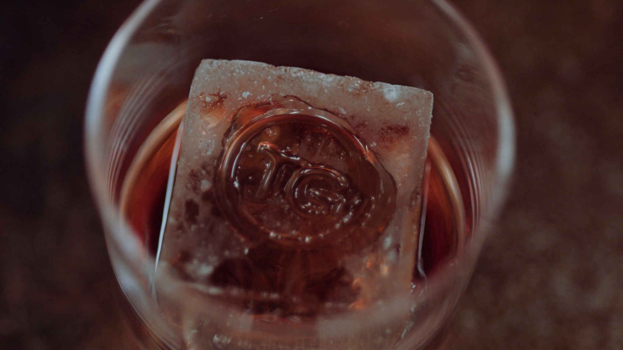 IU C&I Studios Portfolio Taylor Garrett Spirits Closeup of ice with logo in glass of whiskey