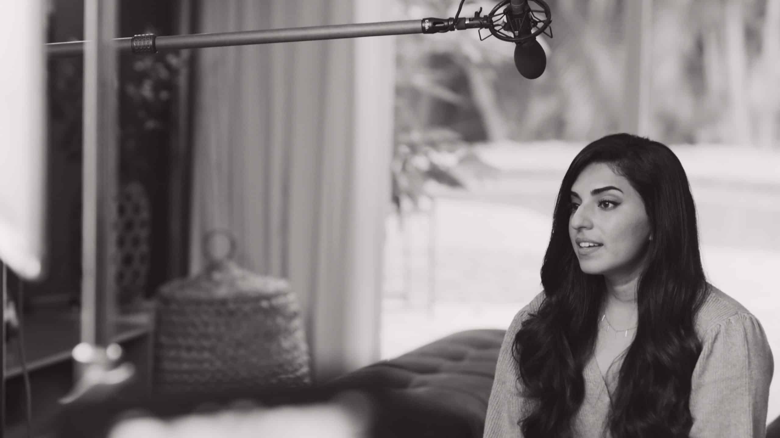 Black and white side profile of woman with long hair being interviewed