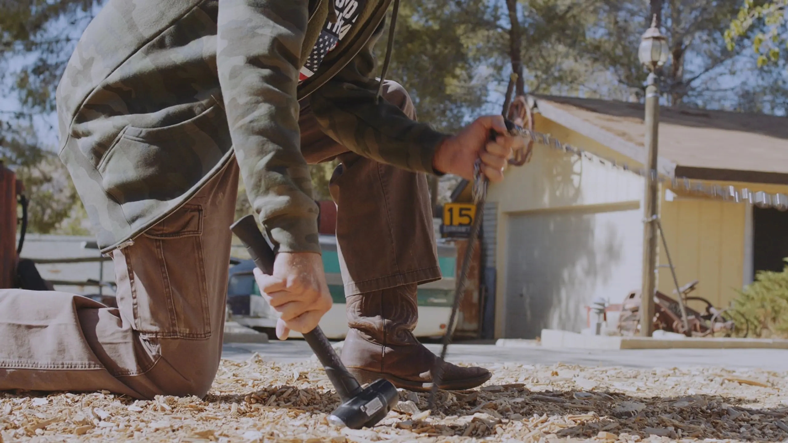 Bart McCarthy - Q Guy 9 Side profile of rancher kneeling with a mallet and stake