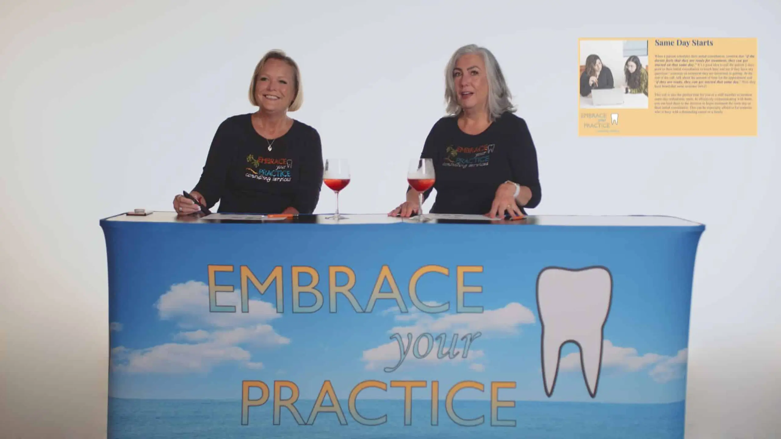 Embrace Your Practice 3 Two women sitting at a table with banner and glasses of wine talking