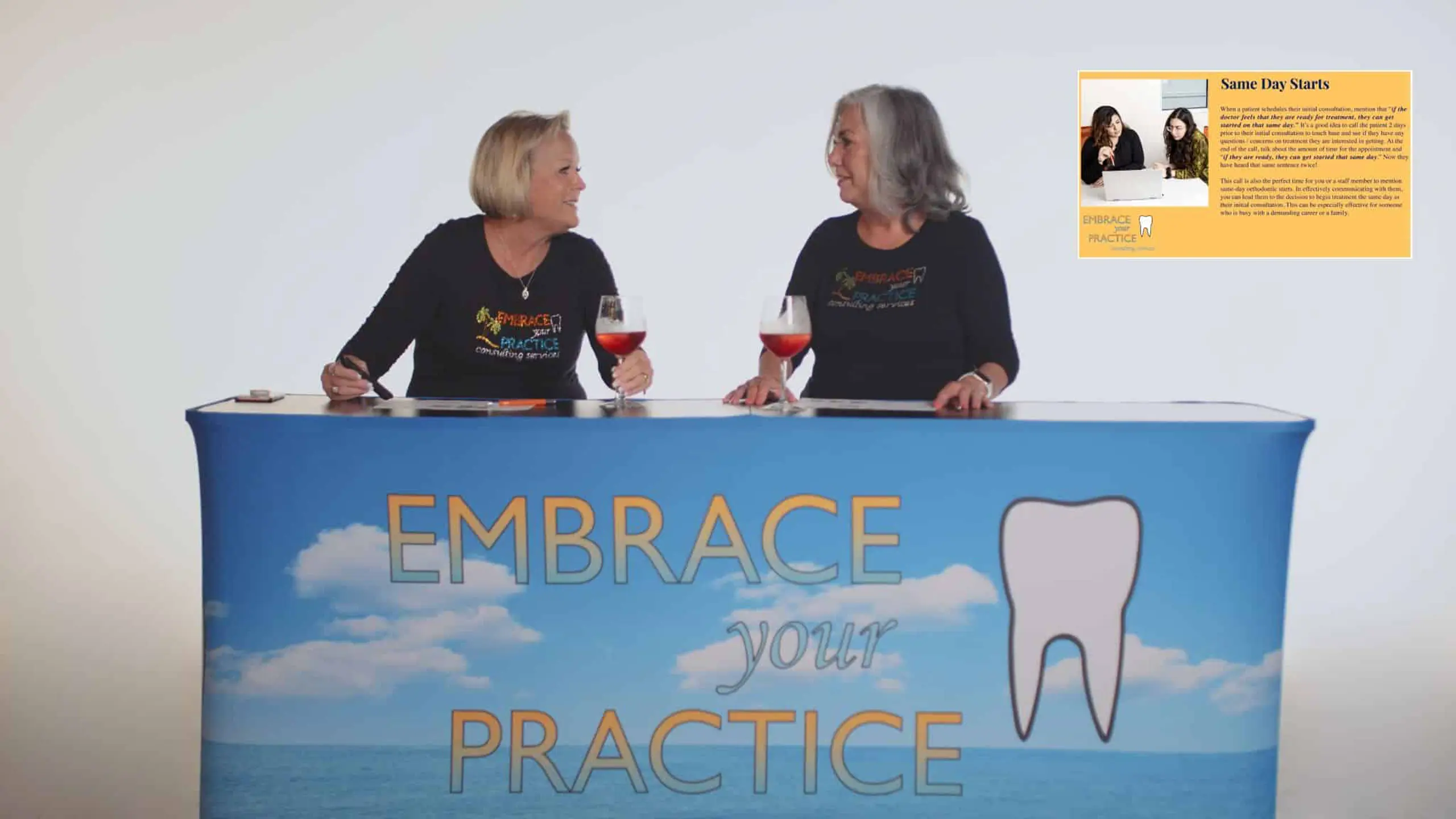 Embrace Your Practice 4 Two women sitting at a table with banner and glasses of wine smiling at each other