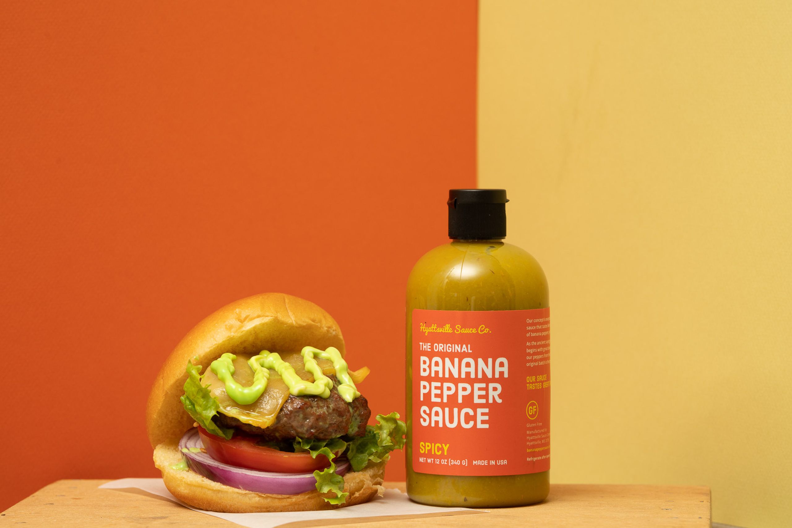 IU C&I Studios Page Banana Pepper Sauce bottle on display with loaded hamburger next to it