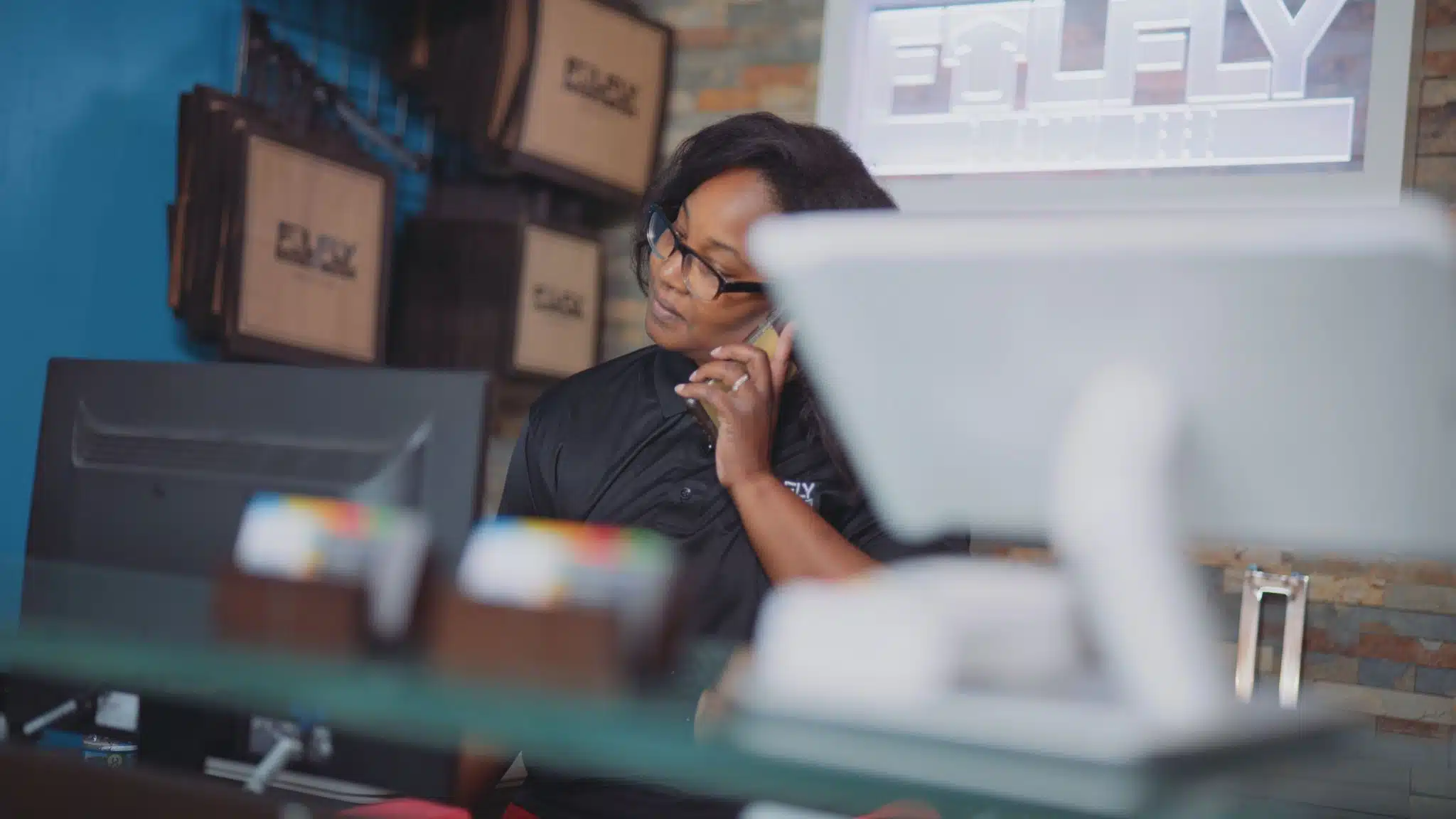 African American woman taking a phone call using a computer