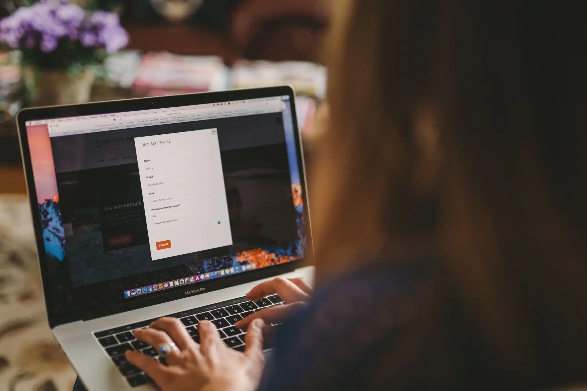 Over the shoulder view of woman with long hair using a laptop