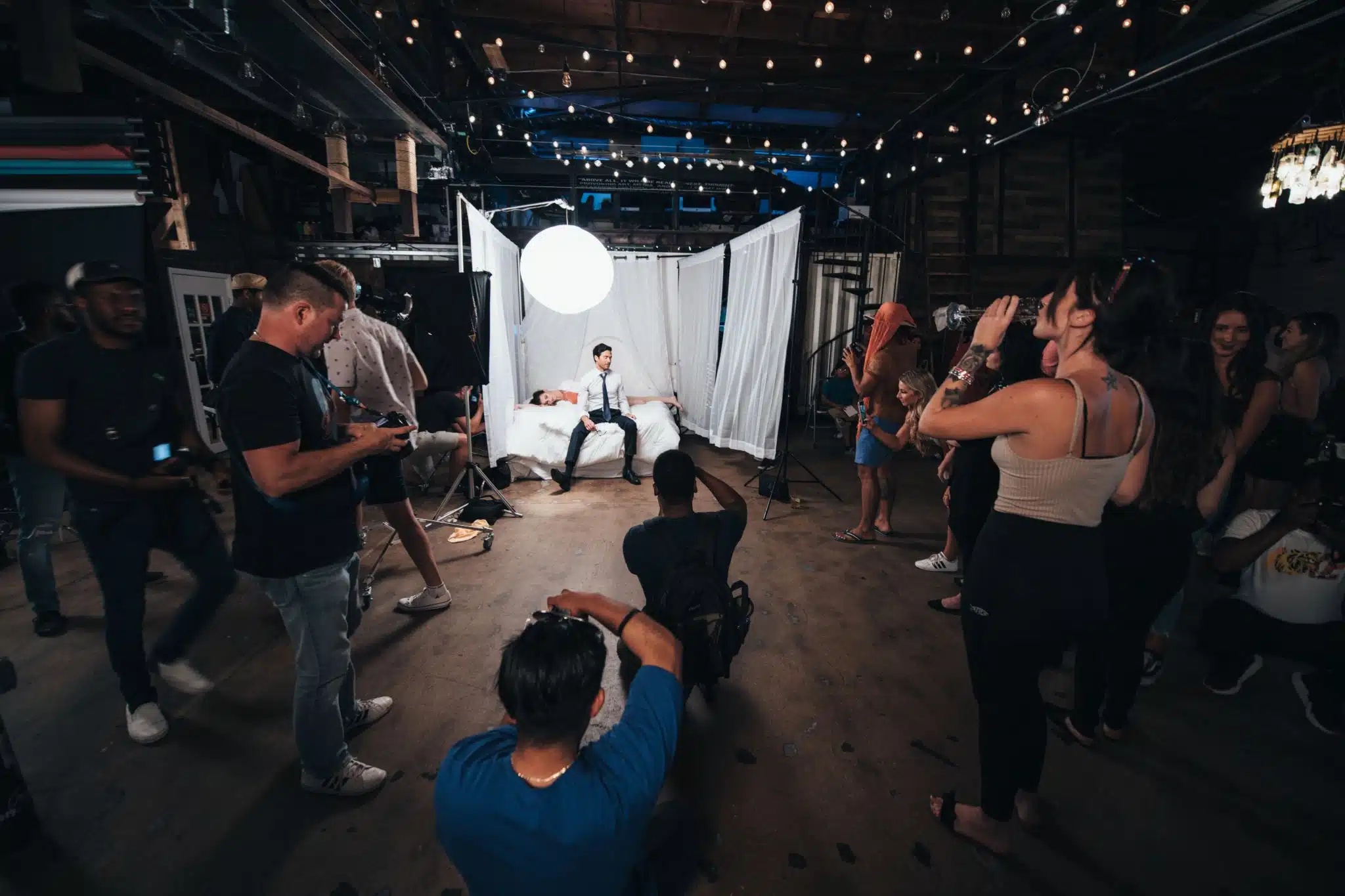 Crew filming on set a man and woman on a bed