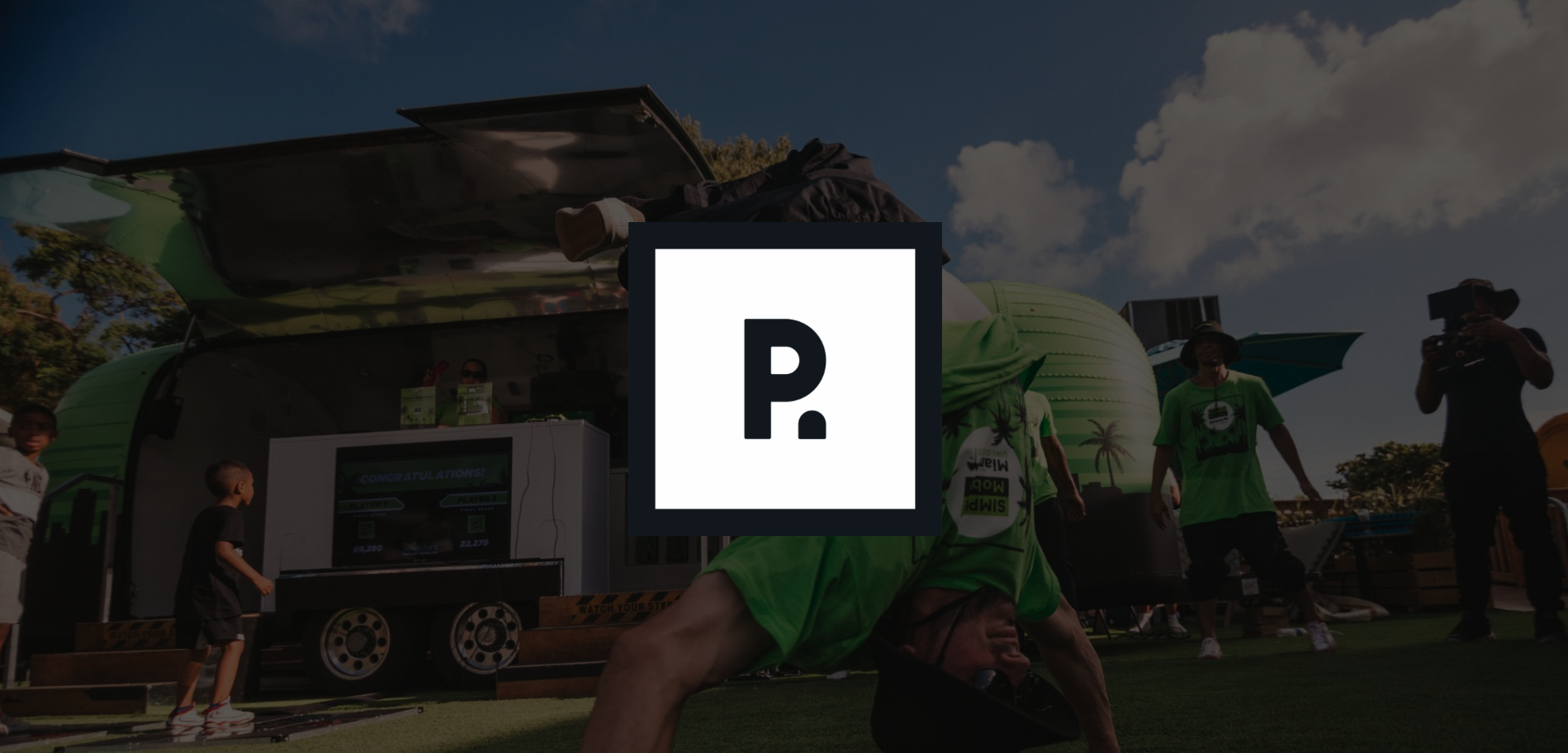 IU C&I Studios Page Pierce Promotion Cover with a black and white logo against a backdrop of Simple Mobile employees by company van with one doing a headstand