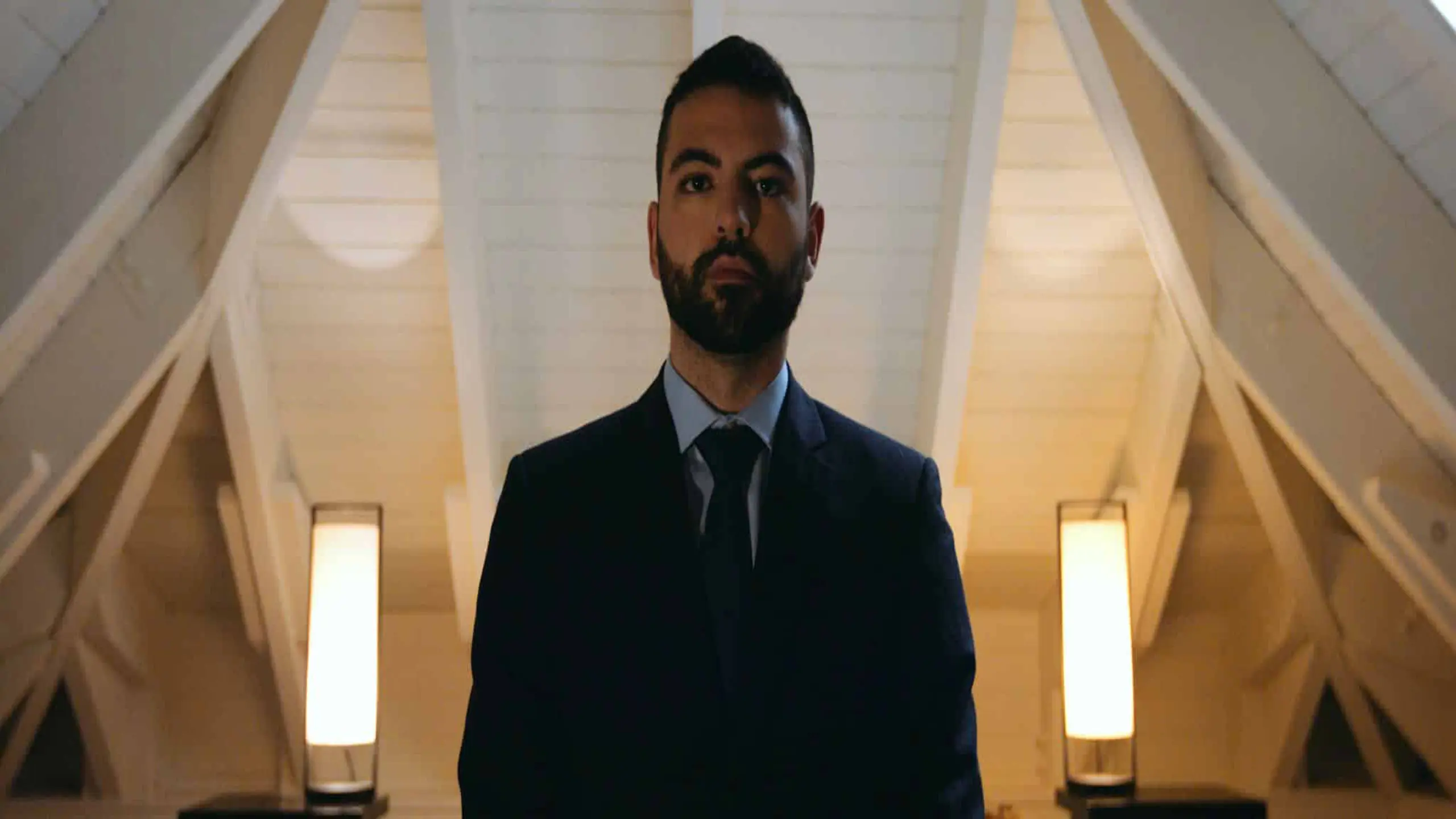 Man with short beard and hair looking down at camera