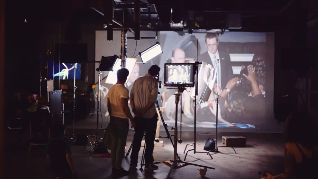 View from behind of two crew members looking at video projection