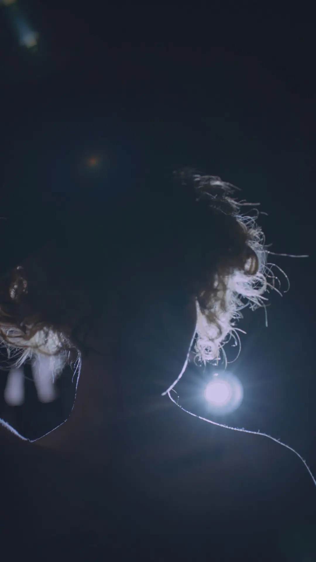 View from behind of Tattoo Projection on a woman in semidarkness