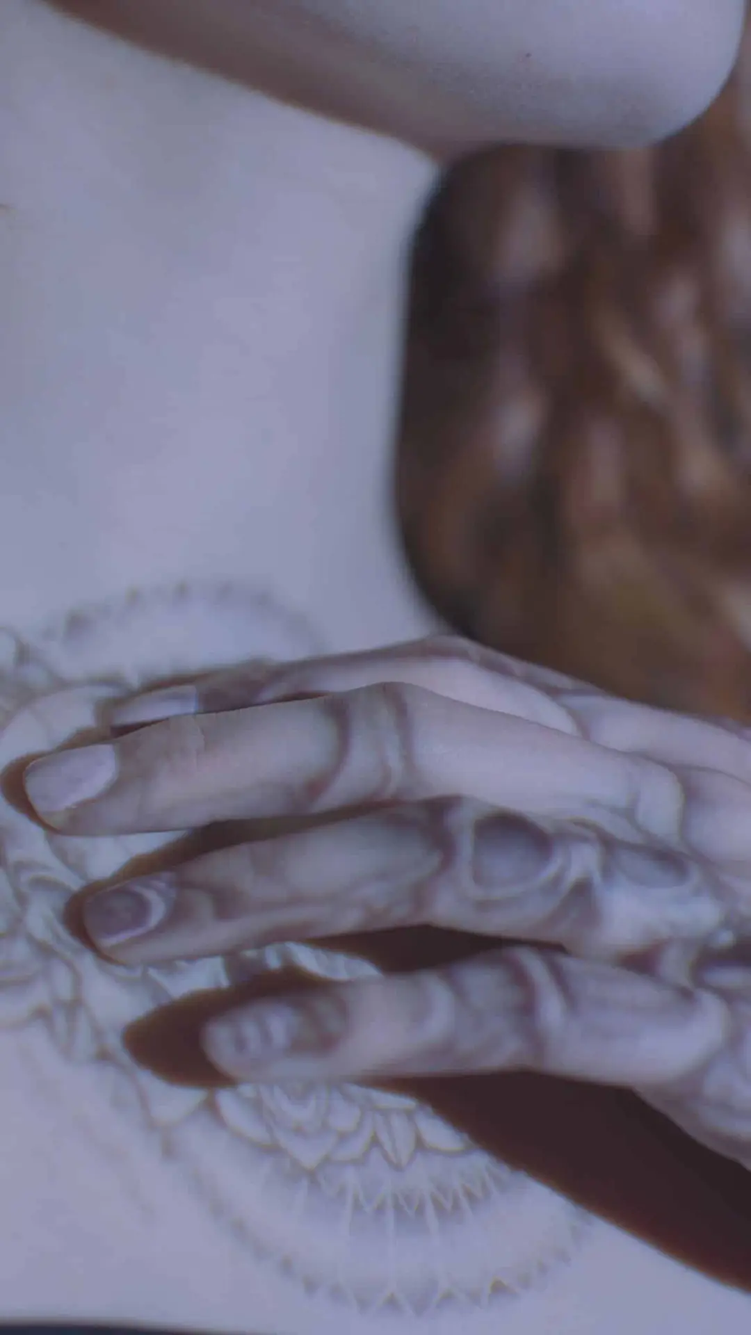 View of tattoo projection on woman's chest and hand