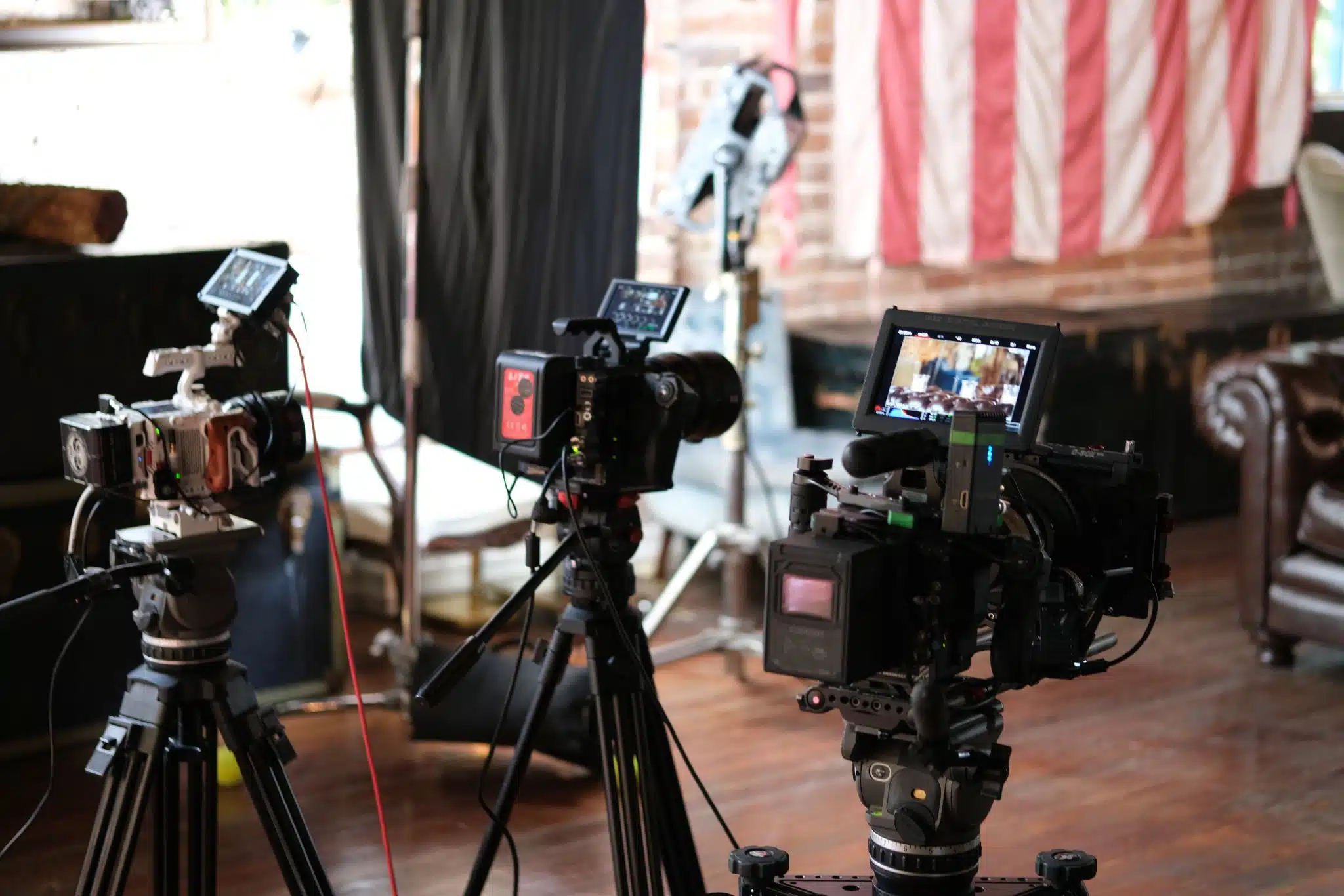 Closeup of three video cameras on display on a set