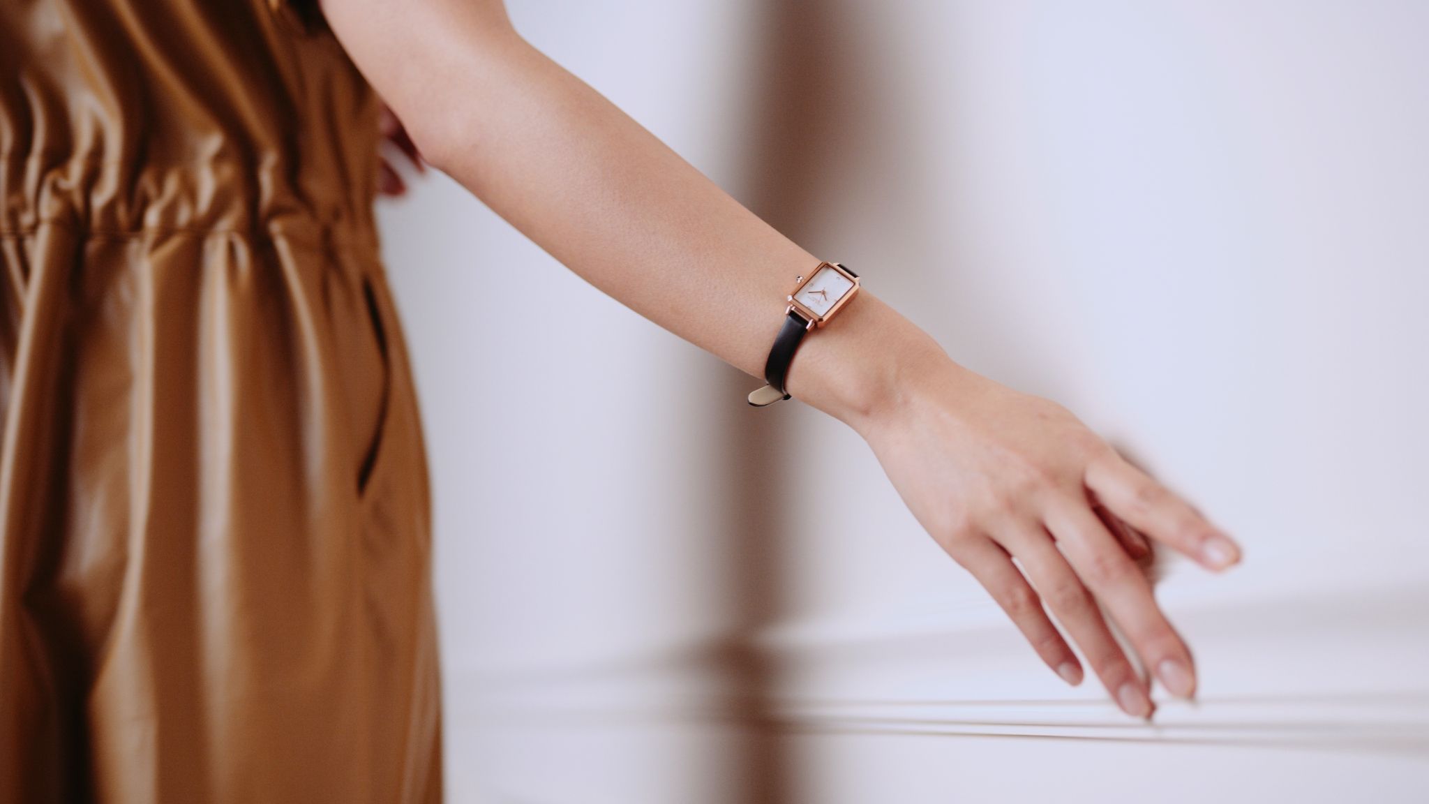 IU CI Studios Portfolio Lola Rose Lifestyle Products 30 second Ad Still Closeup of female wearing a brown outfit with outstretched arm wearing a watch