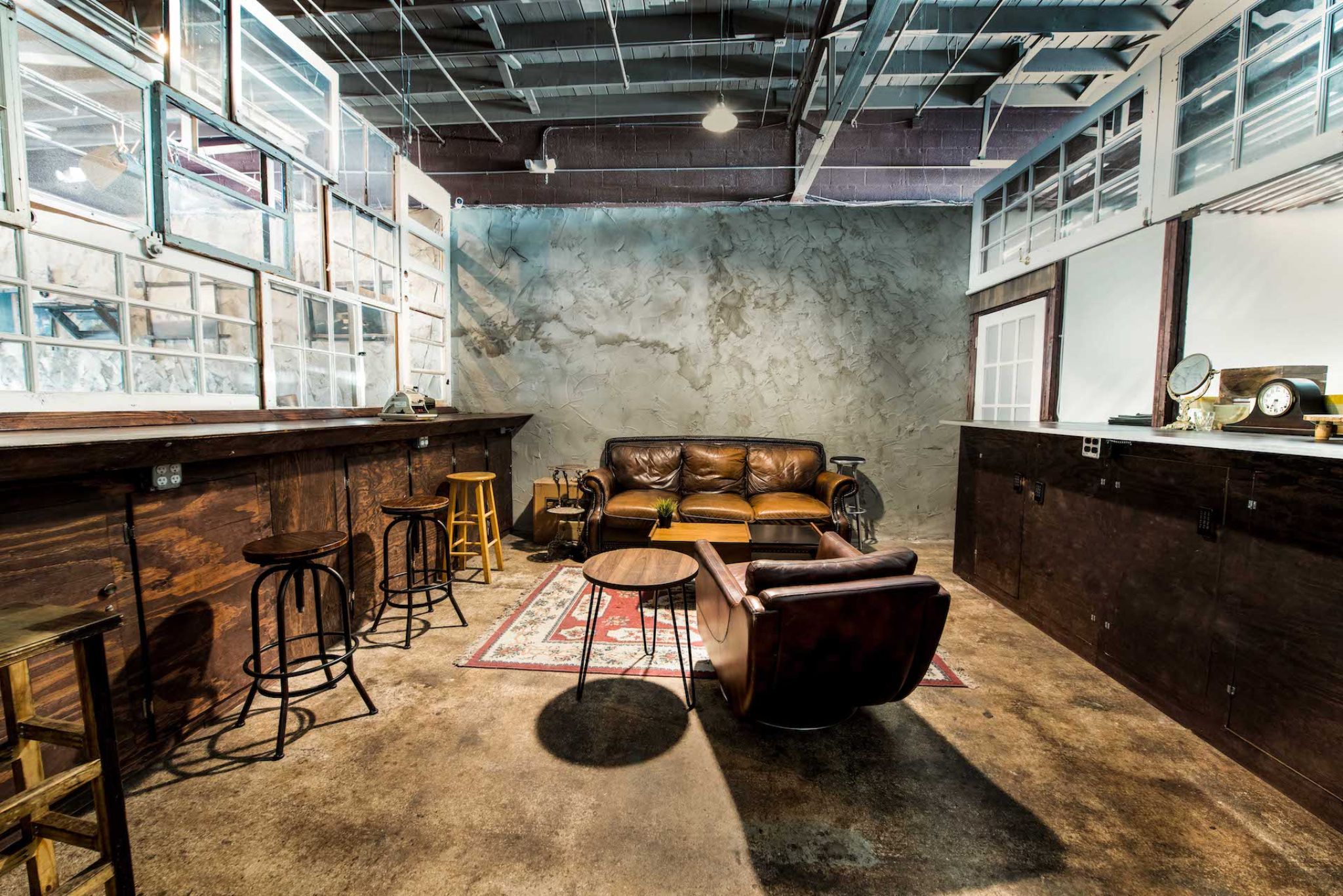 C&I Studios Room With A Leather Couch, Chair And Barstools At A Nextdoor Florida Bar Rental Place.