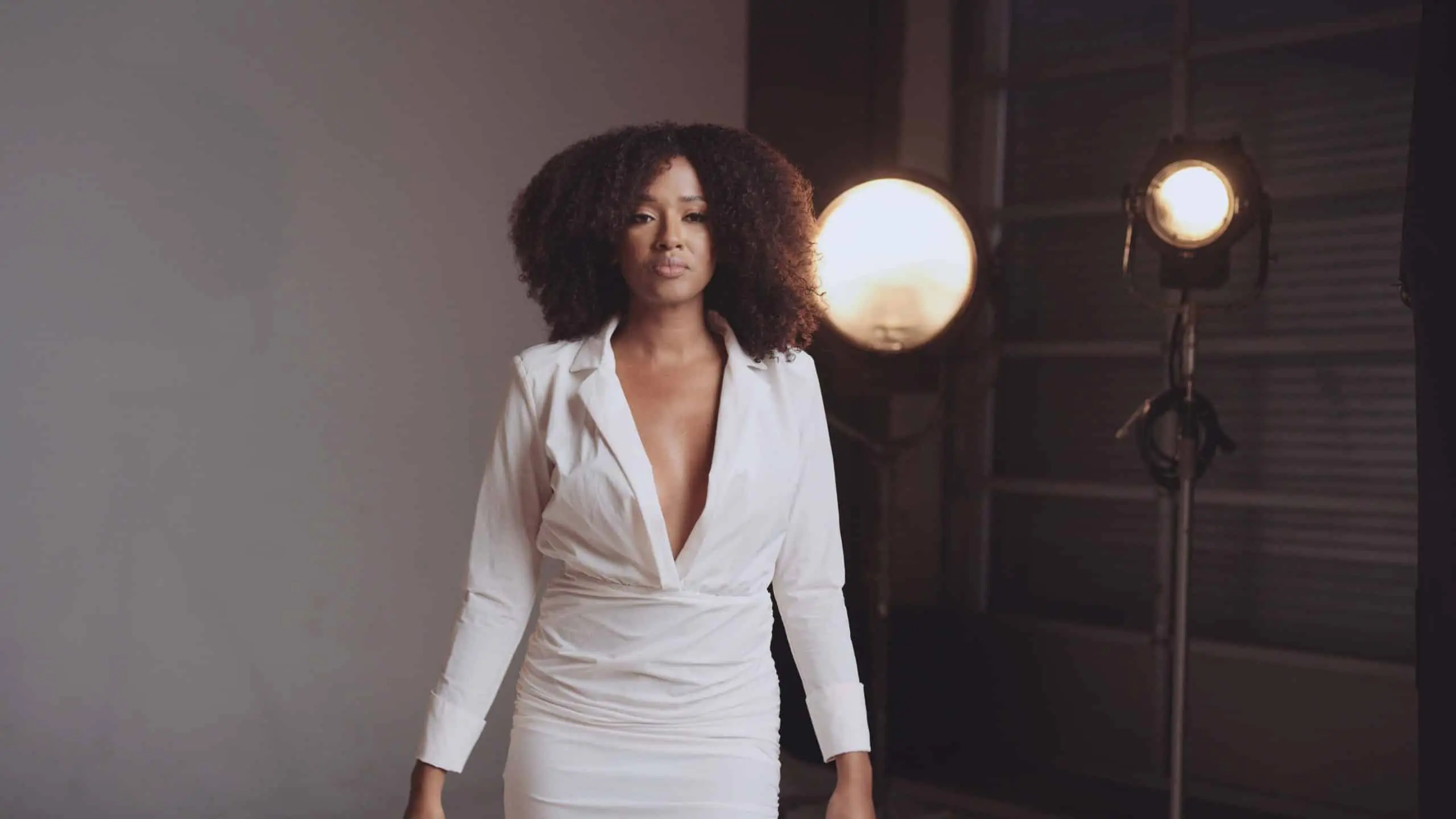 cis-portfolio-all-dolled-up51 Woman with fizzy hair wearing a white dress posing for the camera