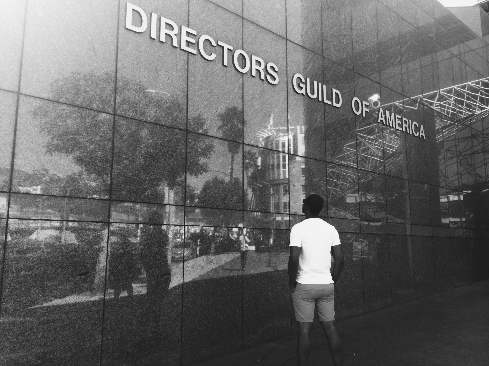 Black and white of Joshua Otis Miller Chief Executive Officer in front of Director's Guild of America building in LA