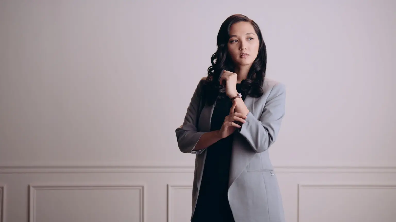 Content Creation Services 9 Asian woman with long black hair wearing a black top with gray dress jacket posing for camera wearing a watch