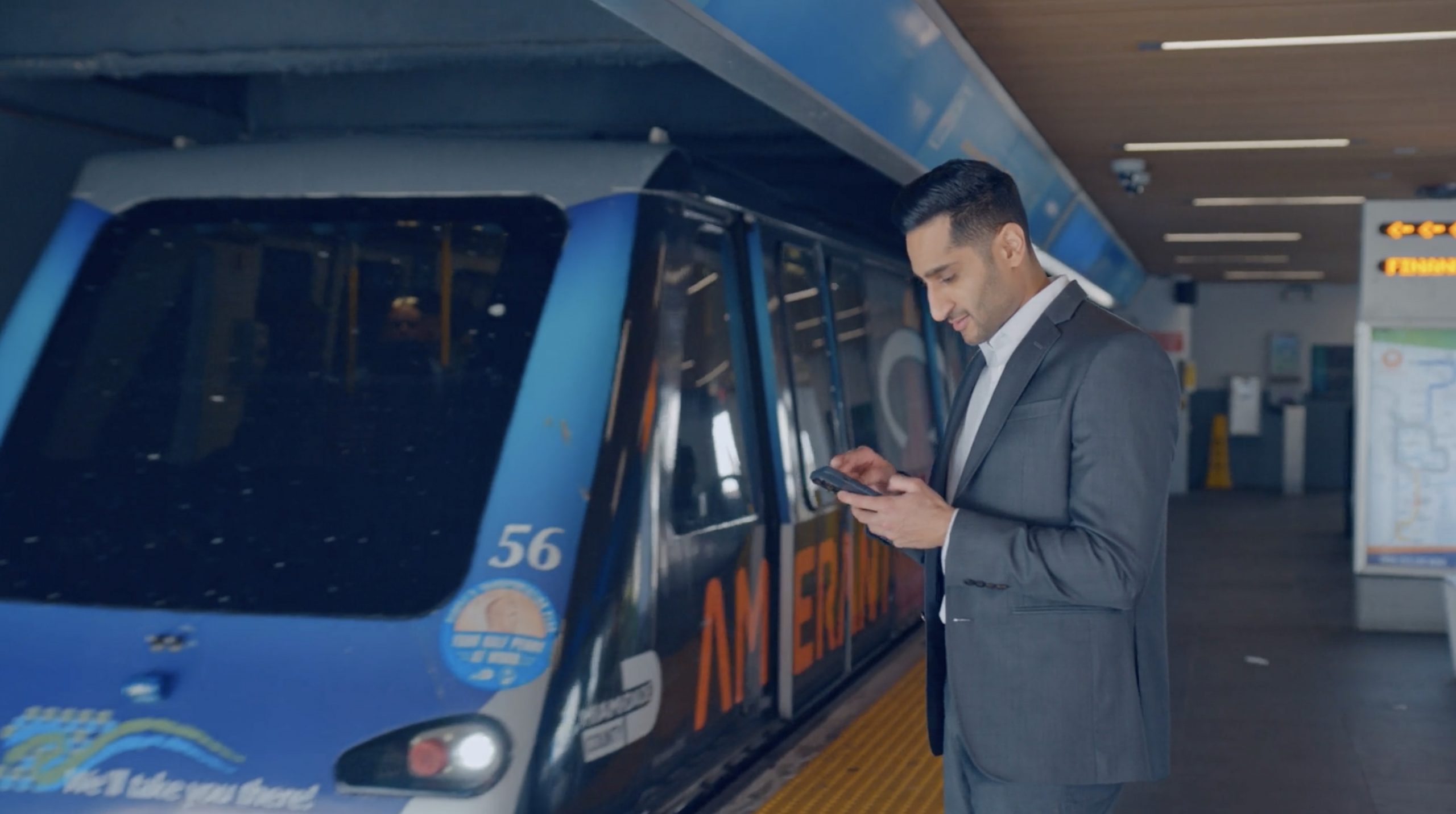 Man in Miami waiting for the public transit tram using iPhone with AT&T 5G network