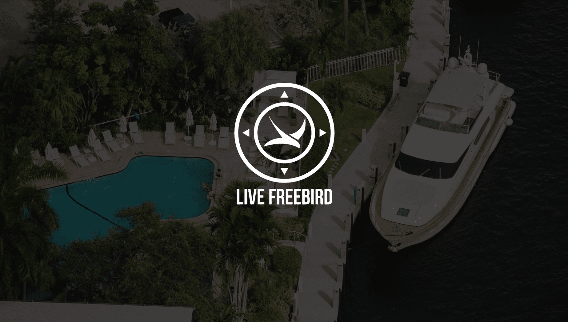 IU seo copywriting services White Live Freebird logo with dimmed background of a yacht by a dock and pool