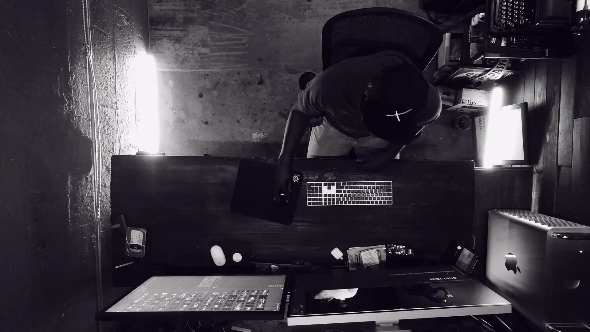 Black and white overhead of crew member working on a desktop